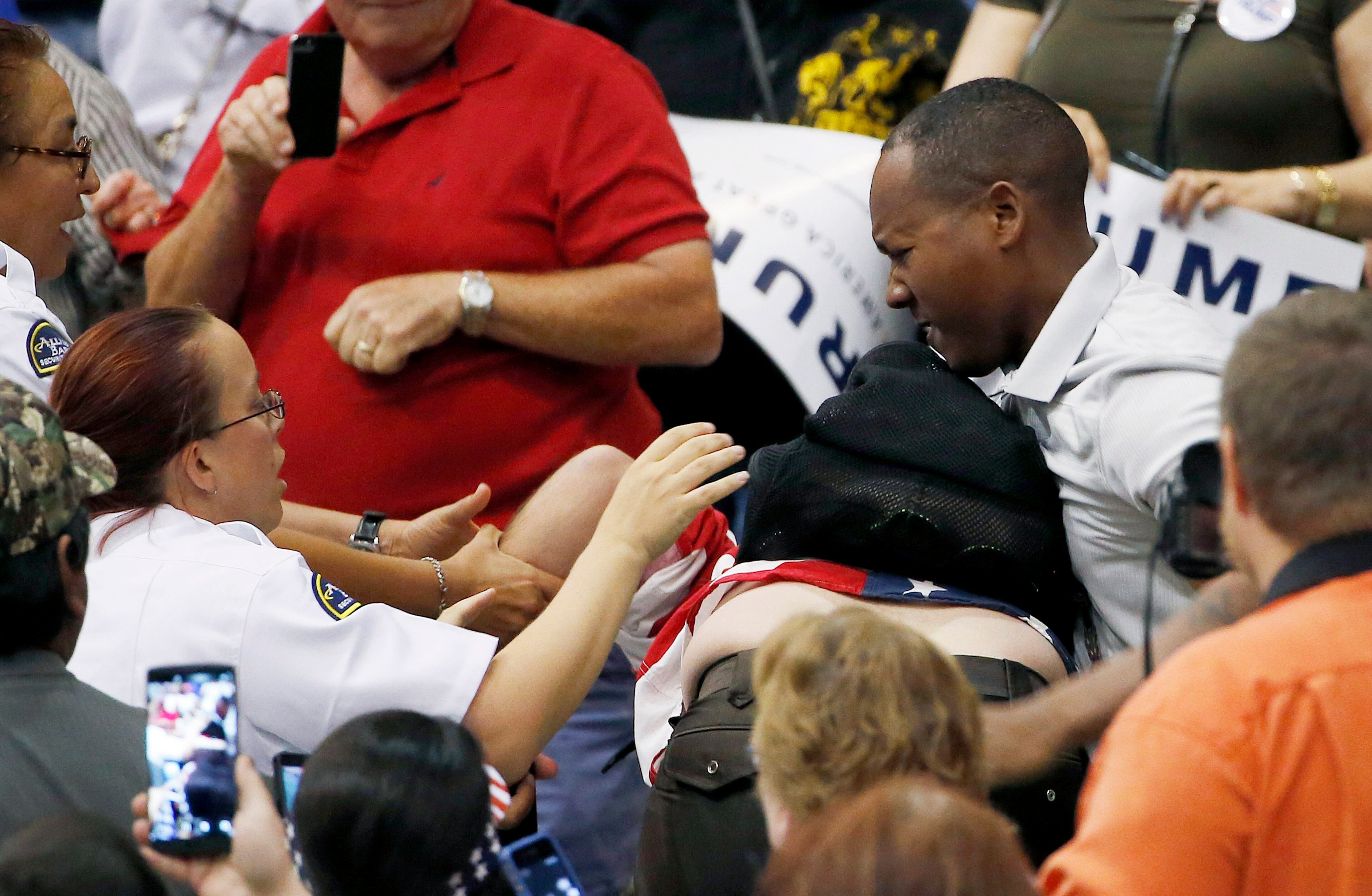 A member of security, left, tries to break up a scuffle between an anti-Donald Trump protester, bottom middle, and another person, right, as the Republican presidential candidate was speaking during a campaign rally Saturday, March 19, 2016, in Tucson, Ariz. (AP Photo/Ross D. Franklin)