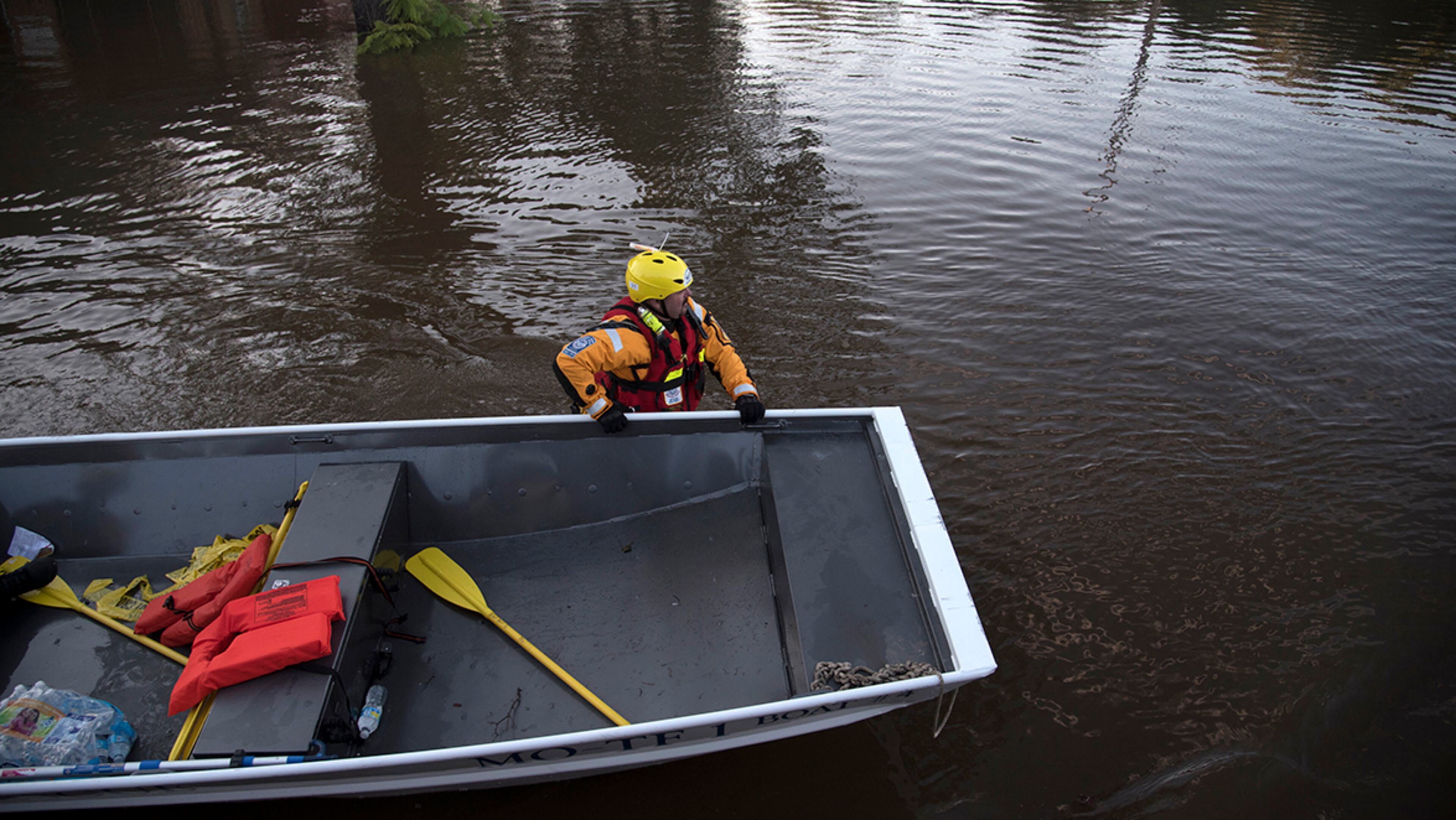 A swift water rescue team member guides a boat through floodwaters caused by rain from Hurricane Matthew in Lumberton, N.C., Monday, Oct. 10, 2016. (AP Photo/Mike Spencer)