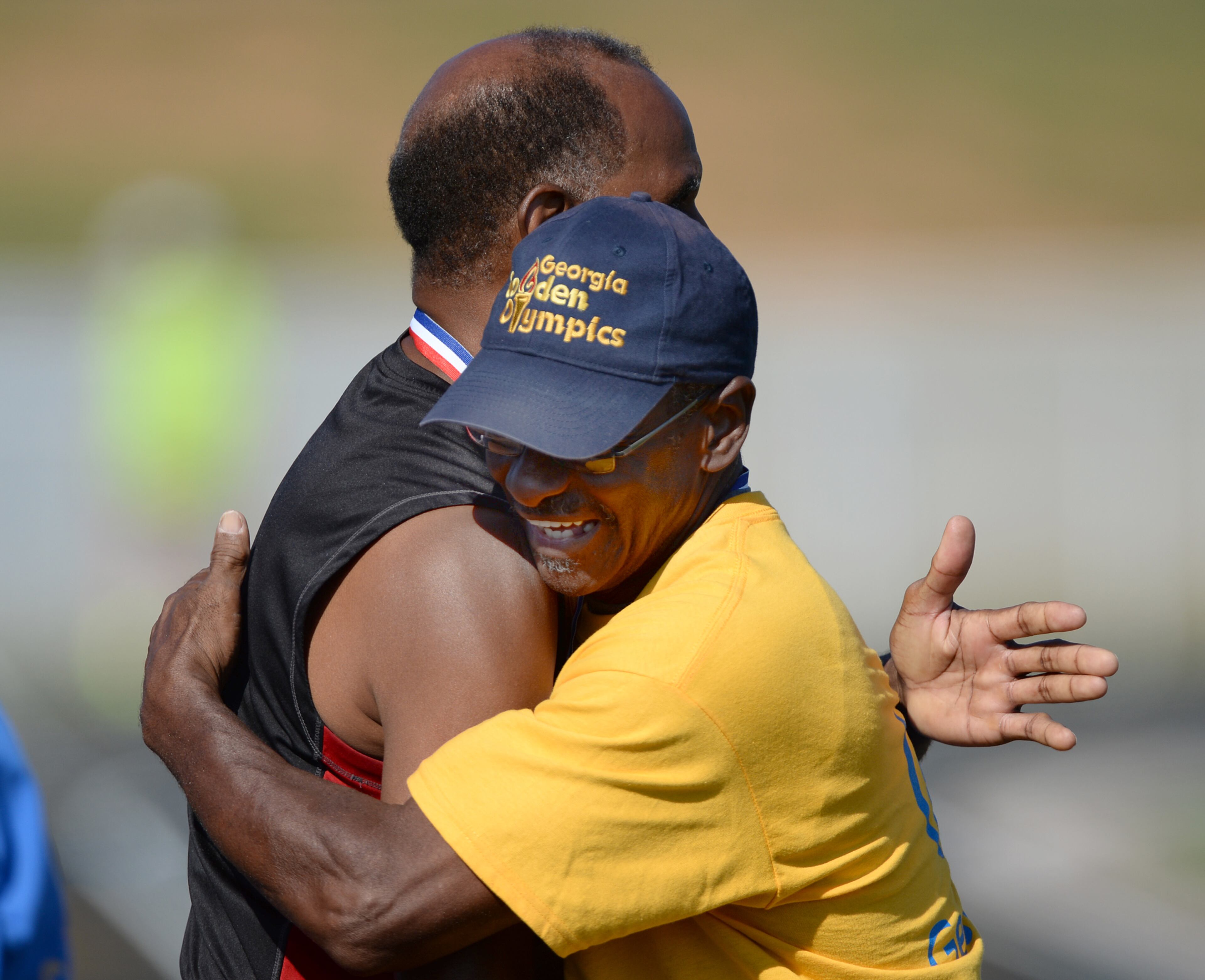 Wilber Bibbs, 69, Warner Robins, hugs Faheem Shabazz, Savannah, Georgia after their 50 meter race during the 31st Annual Georgia Golden Olympics in Warner Robins, Georgia on Thursday, September 19, 2013. Over 430 seniors from age 50 to 92 competed in track & field, swimming, horse shoes, bowling, cycling, checkers, wheelchair, billiards, tennis, and archery. The games started on September 18, 2013 and end on September 21, 2013.