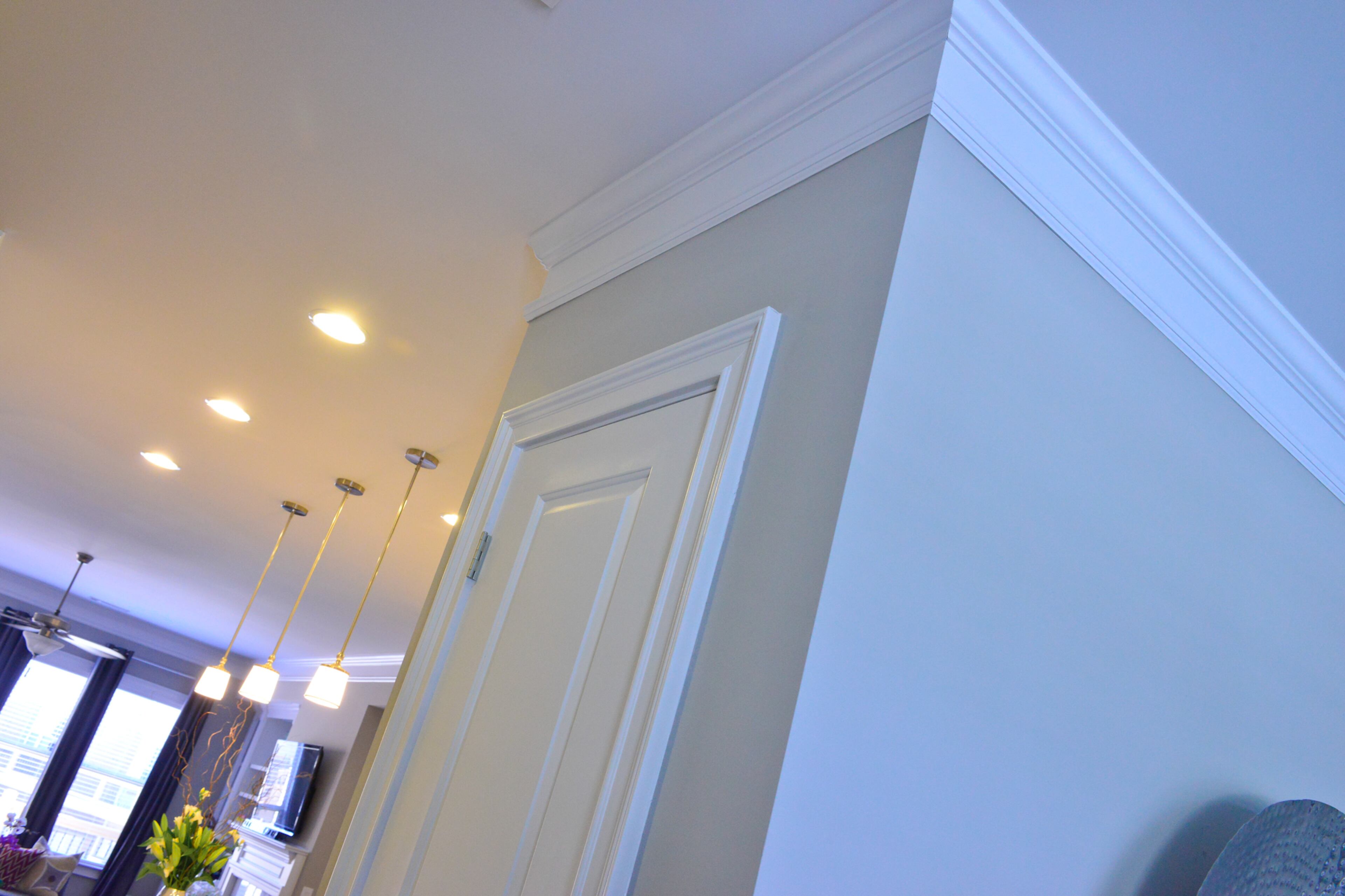 Crown molding finishes off the Sandy Springs townhome by Ashton Woods in the Alderwood community, and the traditional details are mixed with modern pendant lights in the kitchen.