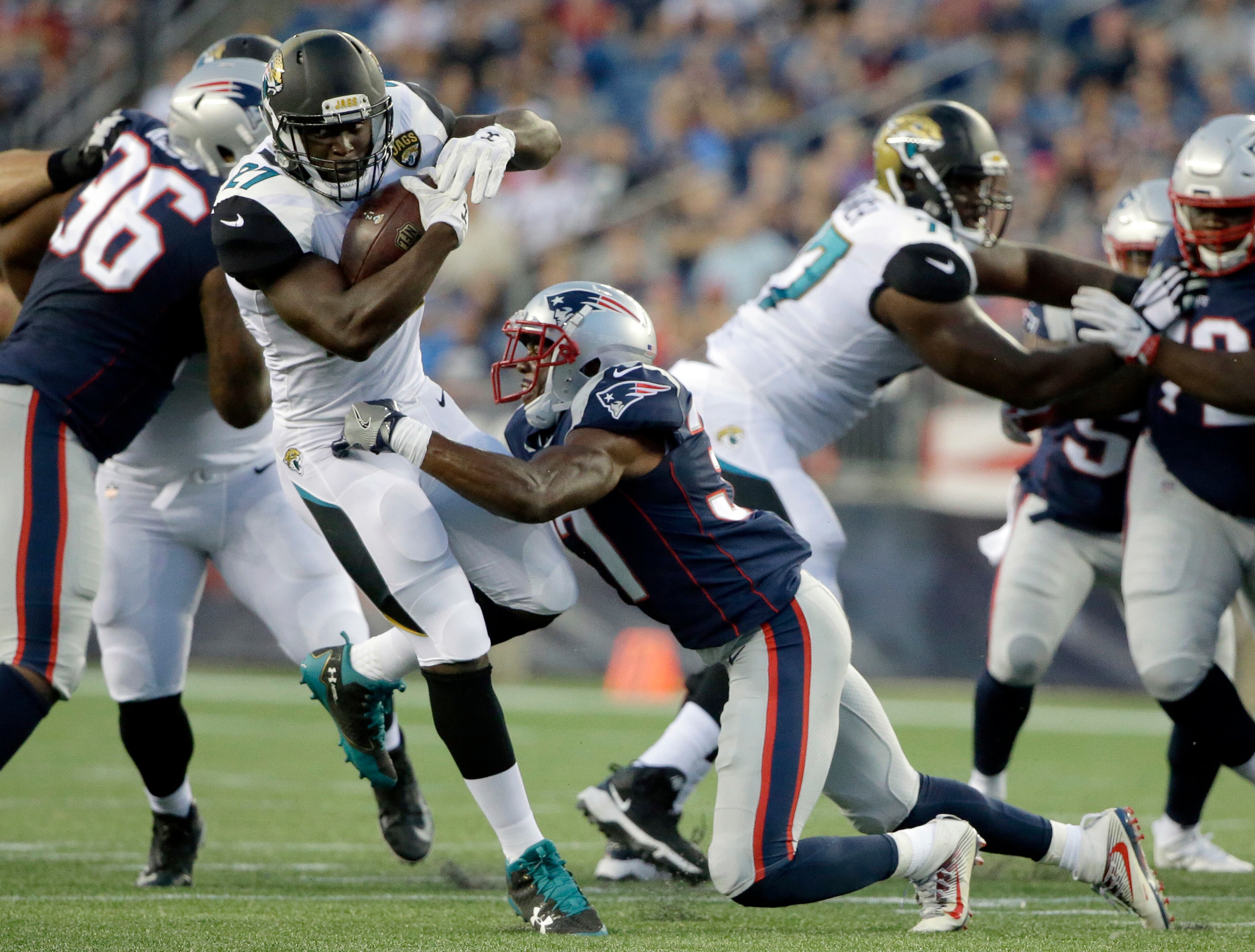 Jacksonville Jaguars running back Leonard Fournette (27) bounces away from New England Patriots safety Jordan Richards, center, in the first half of an NFL preseason football game, Thursday, Aug. 10, 2017, in Foxborough, Mass. (AP Photo/Steven Senne)