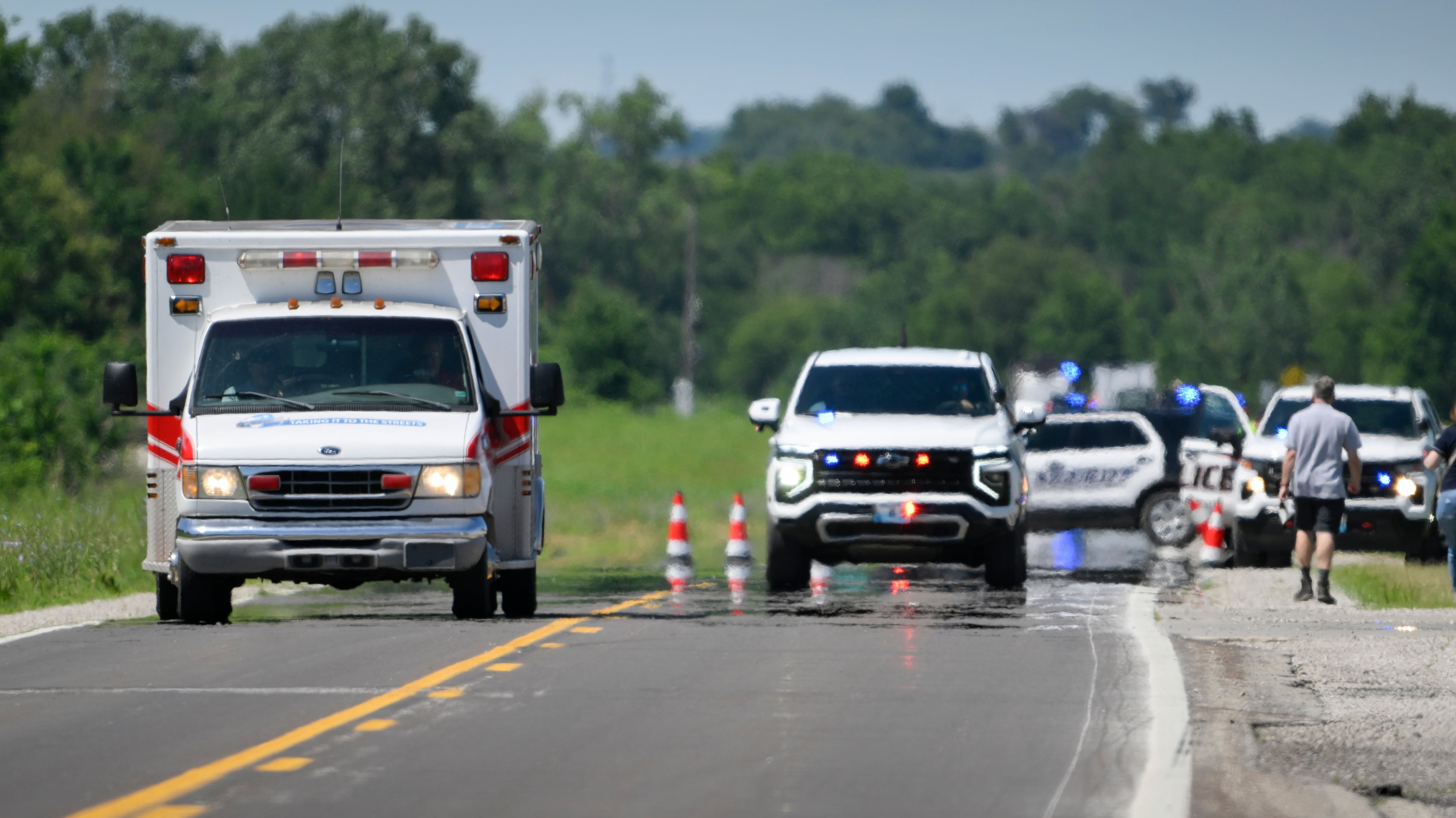 An emergency vehicle leaves the scene of the plane crash at the Butler Memorial Airport in Butler, Mo., Sunday, June 14, 2026. (AP Photo/Reed Hoffmann)