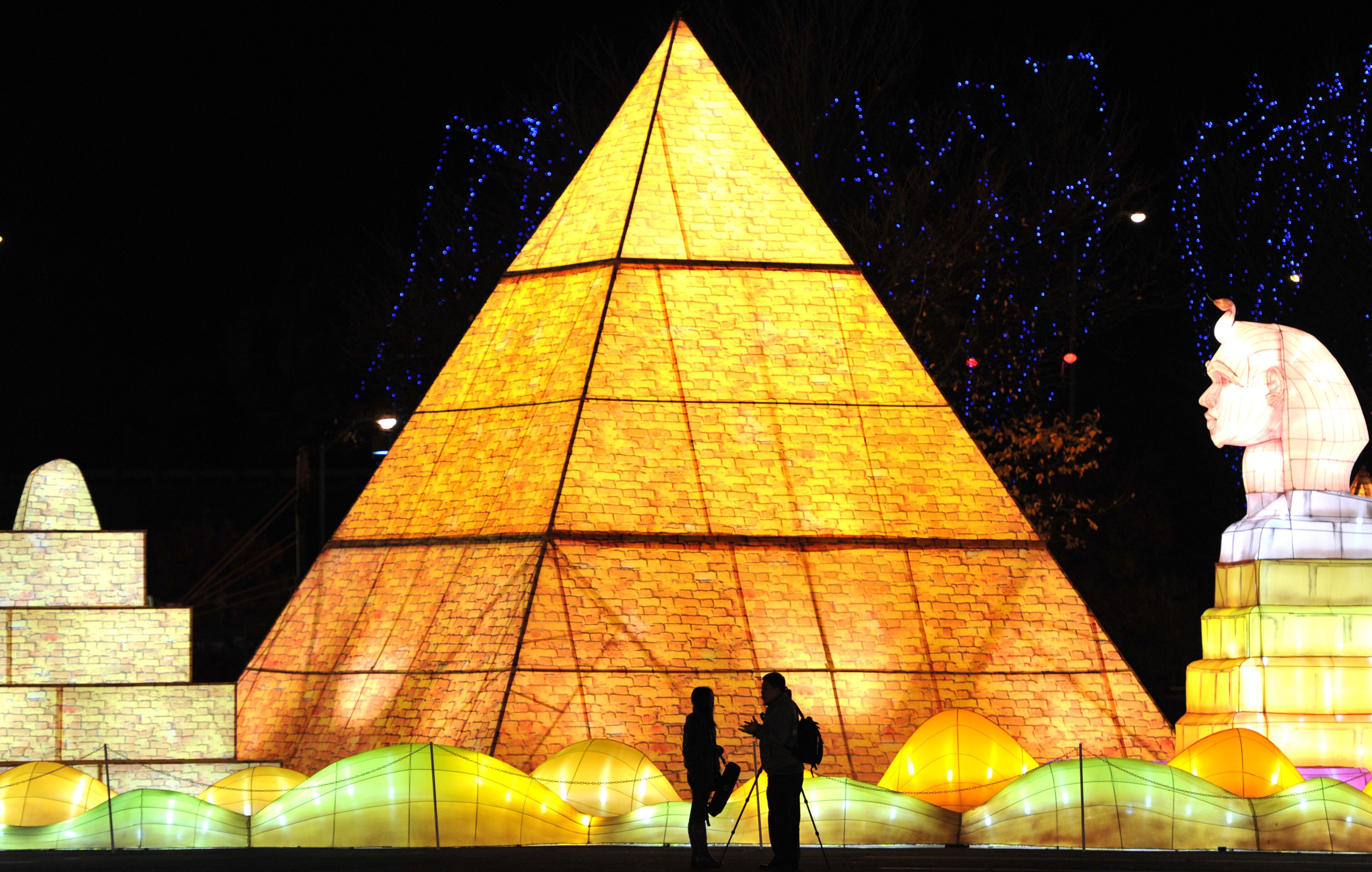 November 19, 2013 Atlanta - Members of media stand in front of a giant illuminated lantern depicting Great Pyramid of Giza before the opening of Global Winter Wonderland Atlanta in the Green Lot at Turner Field on Friday, November 19, 2013. The largest such festival ever presented outside of China, the 2011 U.S. premiere of Global Winter Wonderland featured giant illuminated lanterns depicting creatures and scenes that included a Christmas holiday village, animals real and imagined, and people and scenes from around the world. Global Winter Wonderland Atlanta will be open daily 5pm to 11pm from November 21, 2013 - January 5, 2014. HYOSUB SHIN / HSHIN@AJC.COM