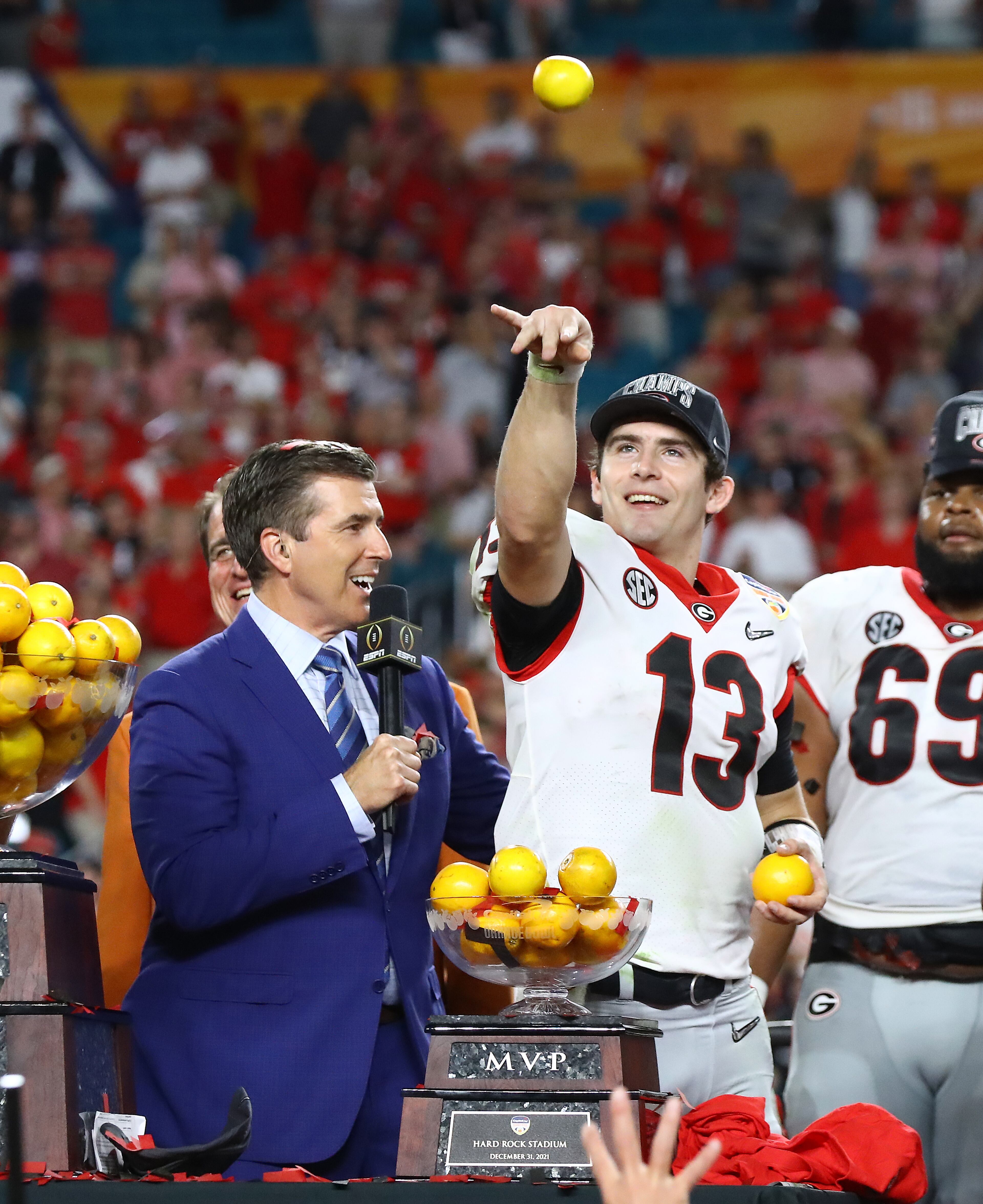 The MVP, Georgia quarterback Stetson Bennett, tosses oranges to teammates as he is awarded the trophy after beating Michigan 34-11 to win the Orange Bowl at Hard Rock Stadium on Friday, Dec. 31, 2021, in Miami Gardens. Curtis Compton / Curtis.Compton@ajc.com