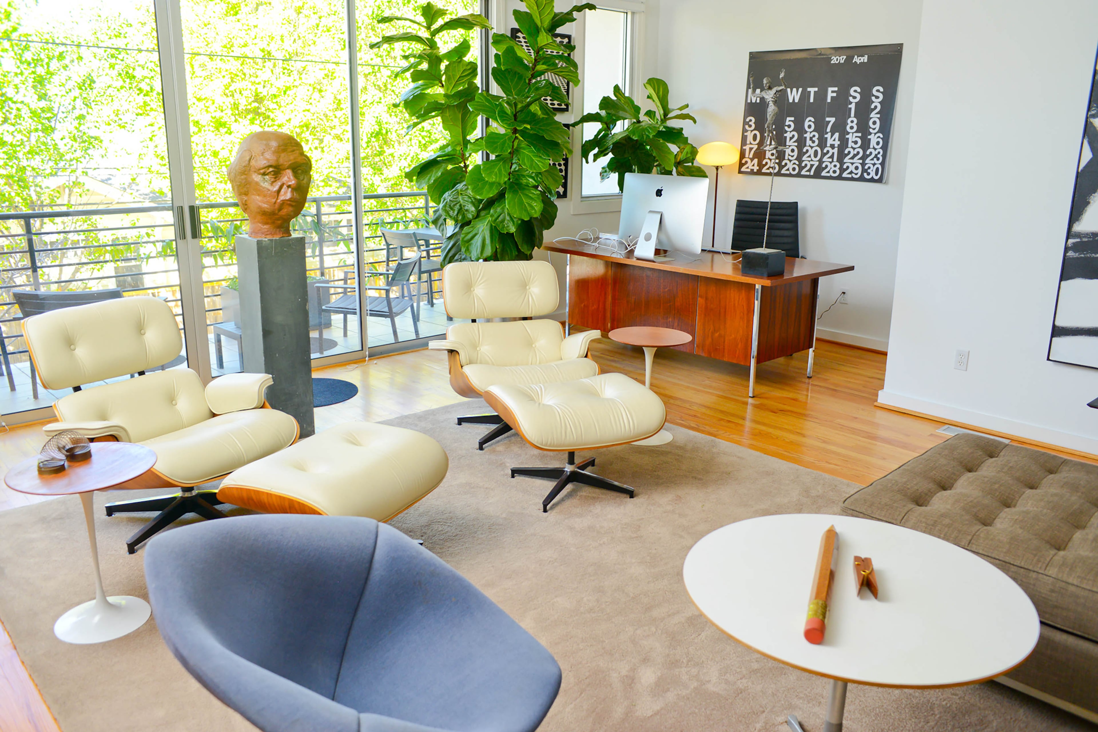 Two white Eames lounge chairs and ottomans, from Herman Miller, are Henry's favorite furniture pieces. Although he decorates with original art and sculpture, houseplants also are part of the decor. "There's so many windows that all the plants just flourish," he said.