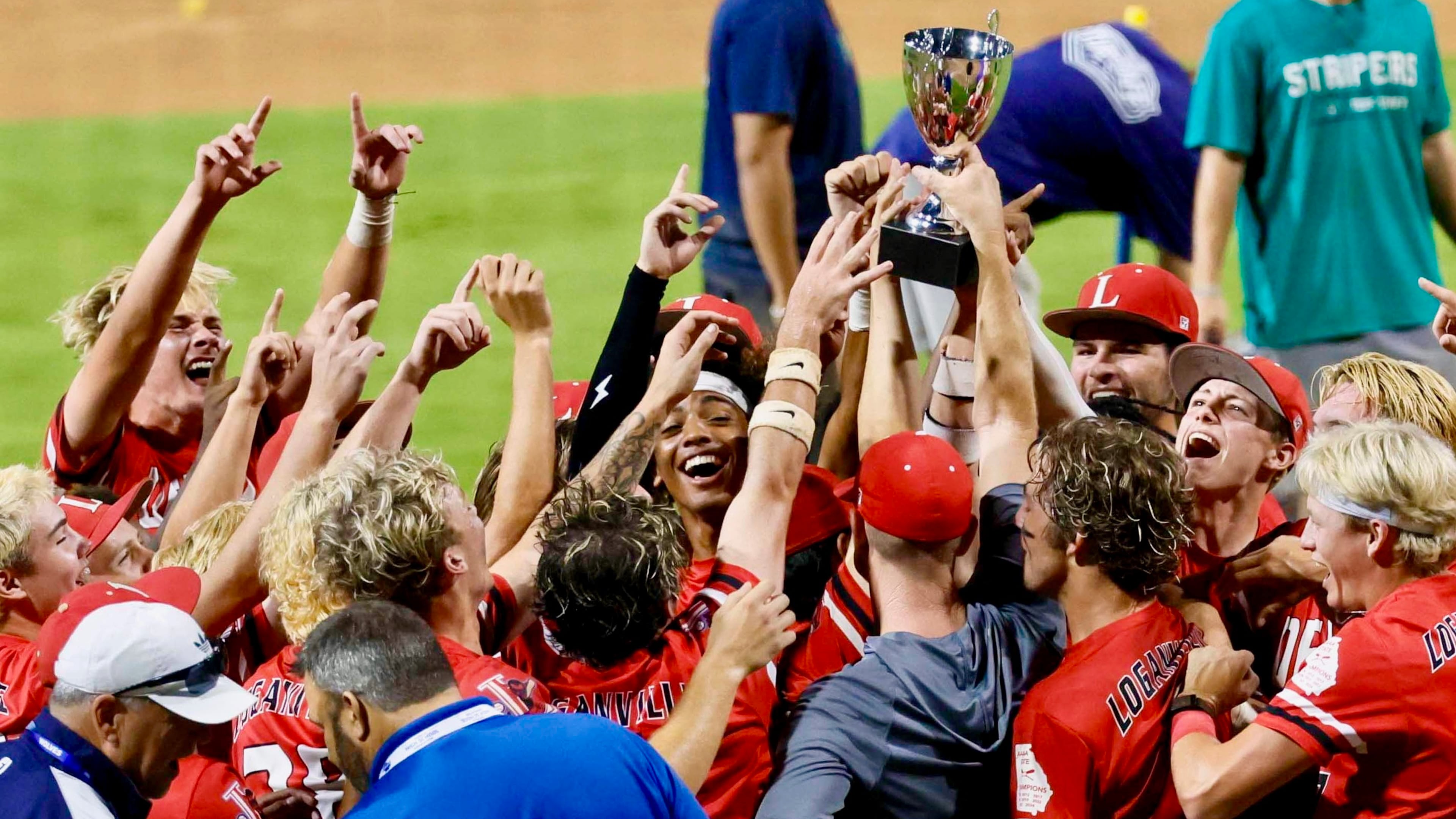 Loganville players and coaches celebrate with the trophy after winning 4-3 against Pope in Game 3 of the Class 5A GHSA Baseball State Championship Series at Gwinnett Field on Tuesday, May 26, 2026, in Lawrenceville. (Miguel Martinez/AJC)