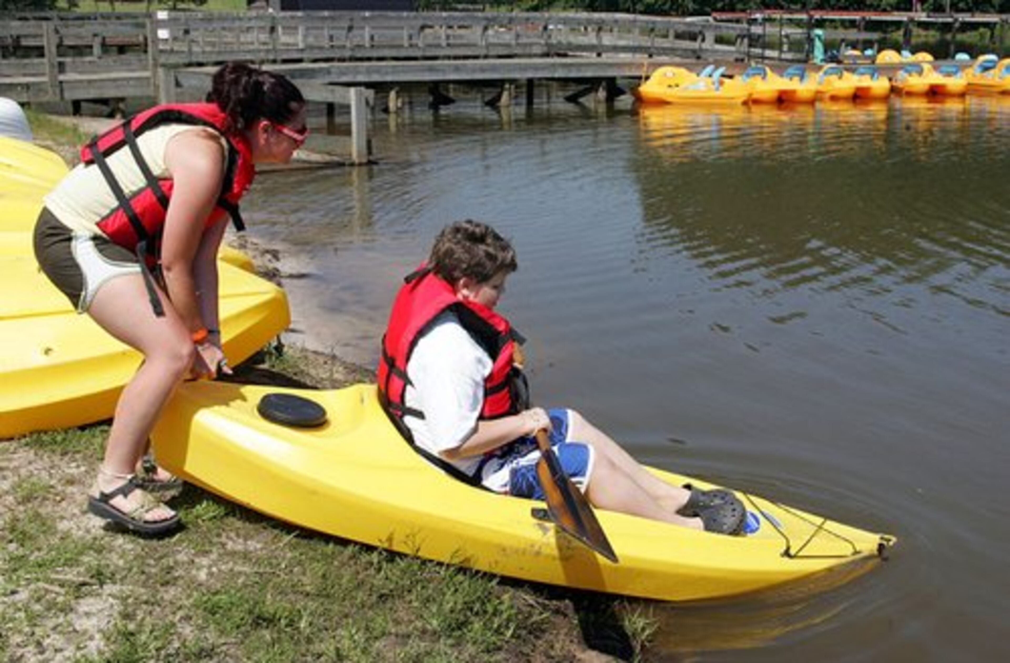 Katie Stapleton (left) launches Mason Loggins in a kayak at the inaugural "Camp Twitch and Shout" camp for kids with Tourette's in Winder.