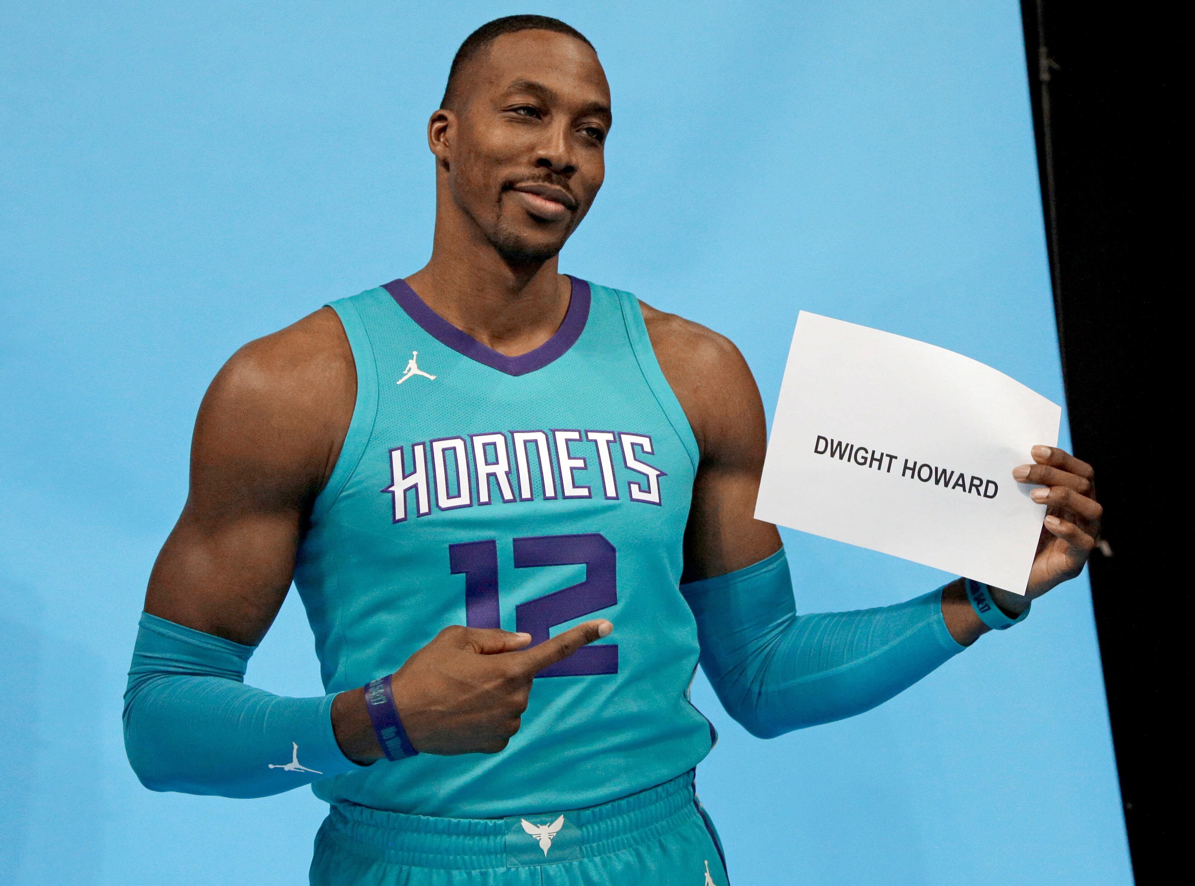 Charlotte Hornets' Dwight Howard jokes with his name tag before he poses for a photo during the NBA basketball team's media day in Charlotte, N.C., Monday, Sept. 25, 2017. The Hornets are banking on Dwight Howard to help them get back to the playoffs after a disappointing season a year ago. (AP Photo/Chuck Burton)