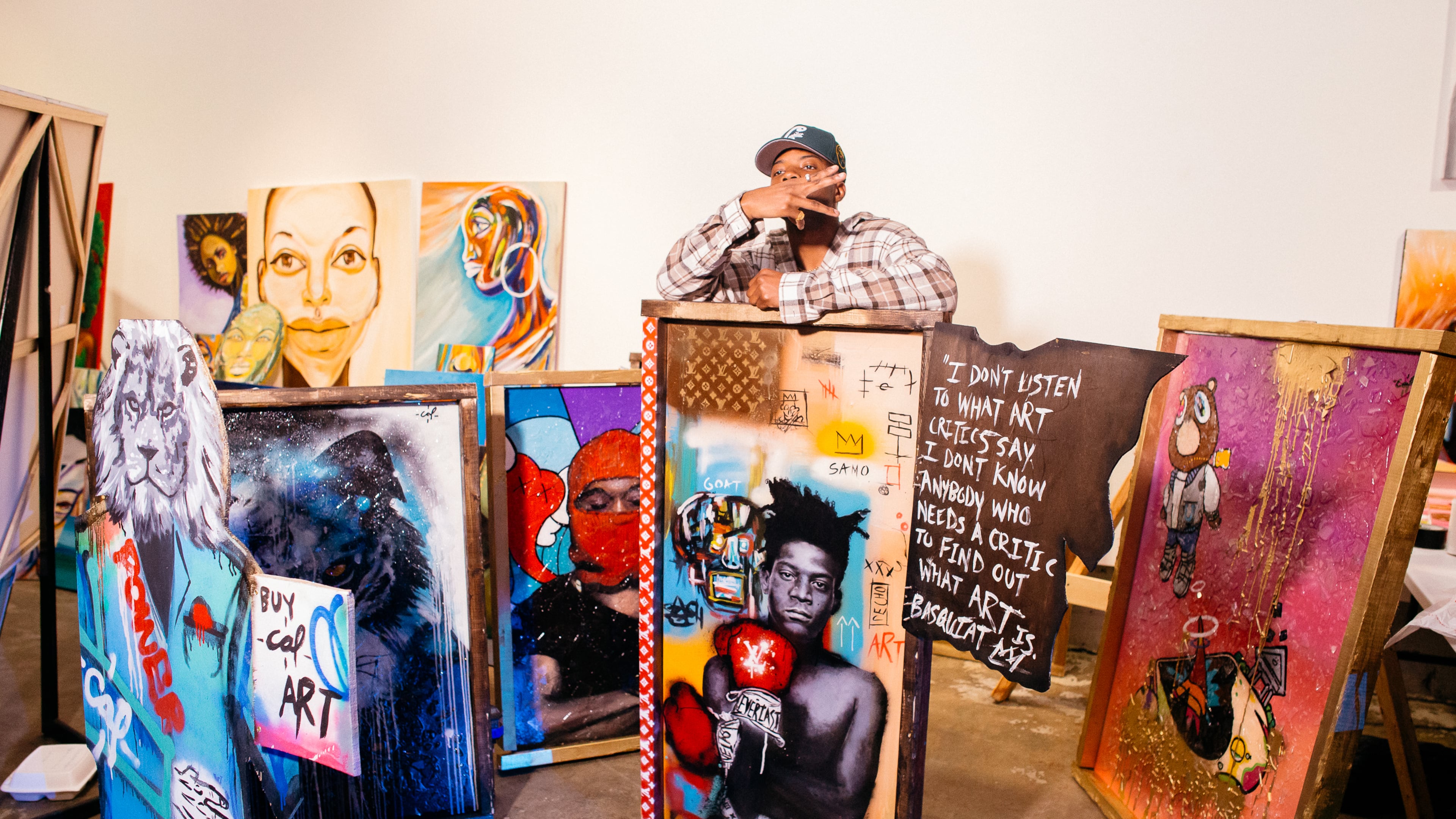 Pictured: Visual artist Cal Art stands with his creations at Black Boy Art Show