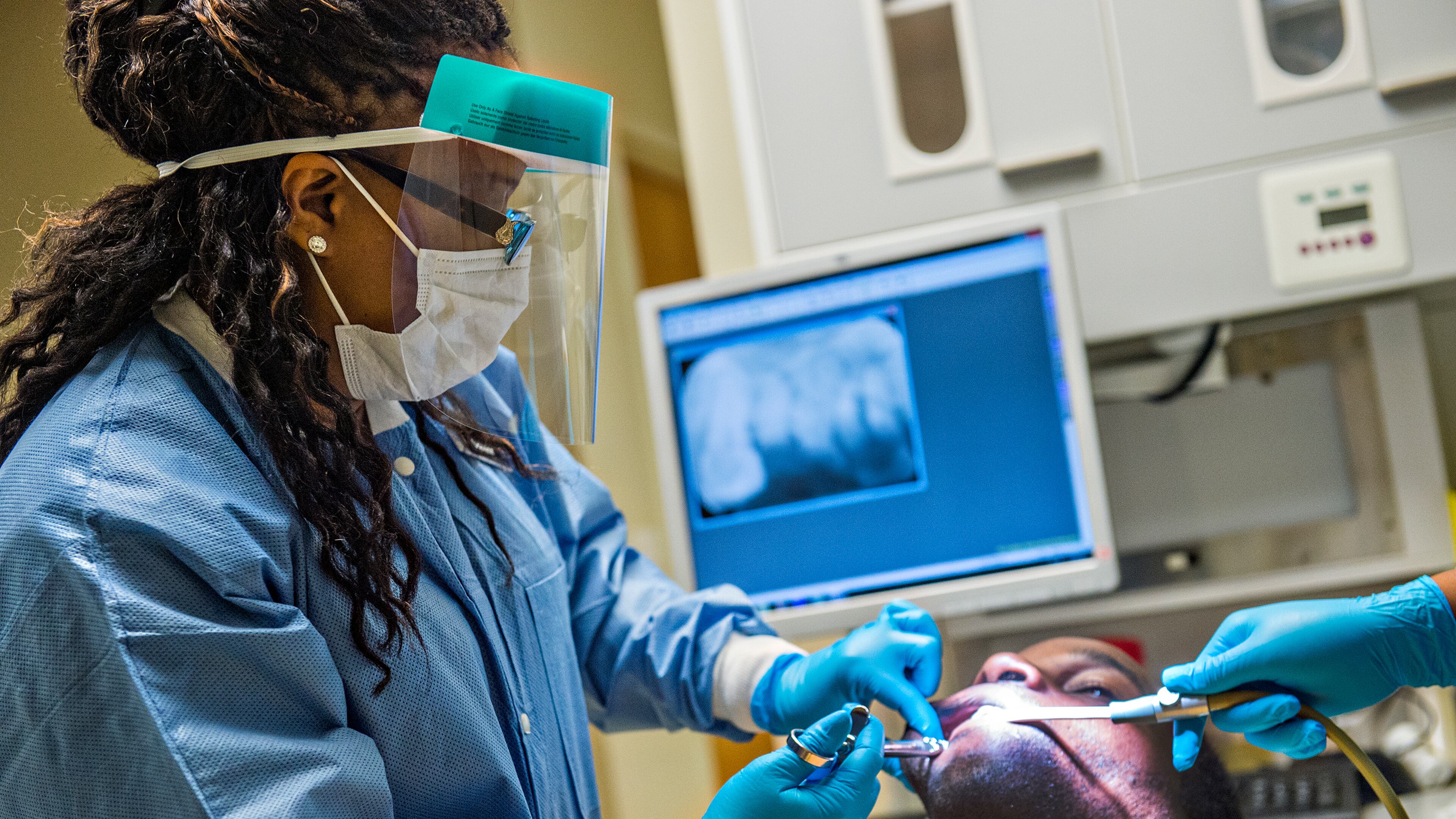 Dr. Katrina Schuler-Bacon (left) gives Marcet Love a shot of numbing medication before pulling one of his teeth at the Mercy Care free dental clinic in Atlanta on Tuesday, May 19. Four and a half million Georgians lack dental insurance, and many of them haven’t seen a dentist in decades. JONATHAN PHILLIPS / SPECIAL