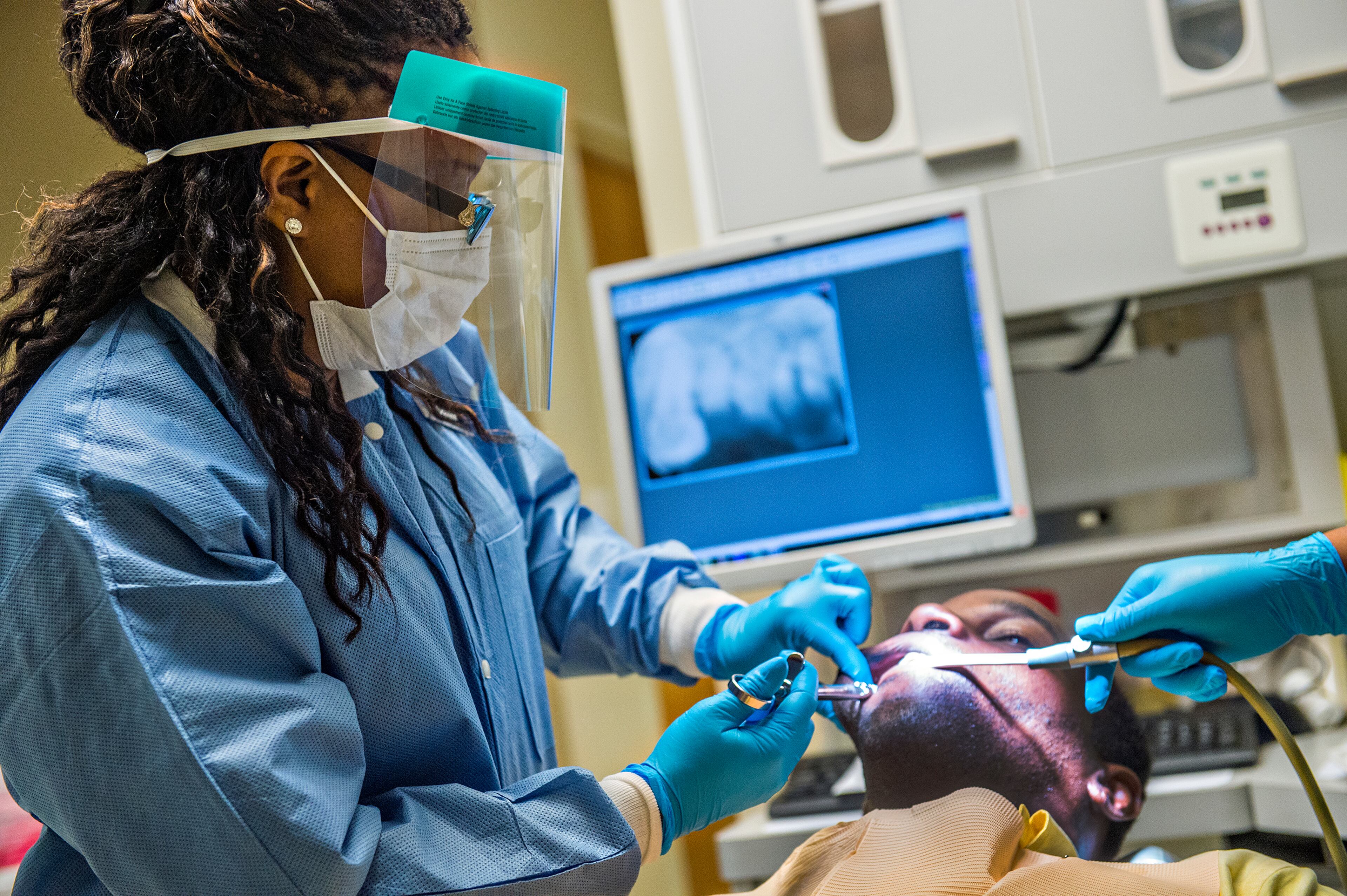 Dr. Katrina Schuler-Bacon (left) gives Marcet Love a shot of numbing medication before pulling one of his teeth at the Mercy Care free dental clinic in Atlanta on Tuesday, May 19. Four and a half million Georgians lack dental insurance, and many of them haven’t seen a dentist in decades. JONATHAN PHILLIPS / SPECIAL