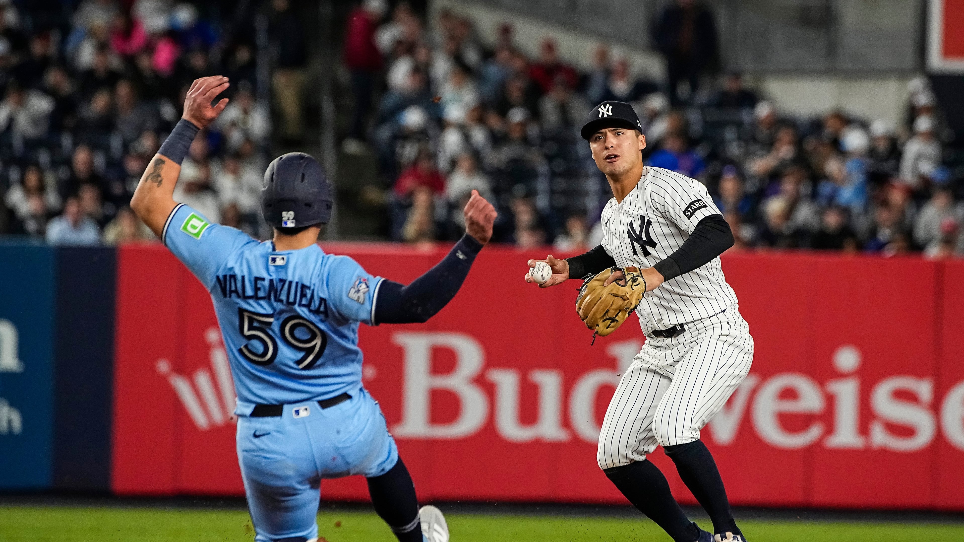 New York Yankees shortstop Anthony Volpe, right, throws to first base after forcing Toronto Blue Jays Brandon Valenzuela (59) out at second base on a double play, during the ninth inning of a baseball game, Thursday, May 21, 2026. in New York. (AP Photo/Eduardo Munoz Alvarez)