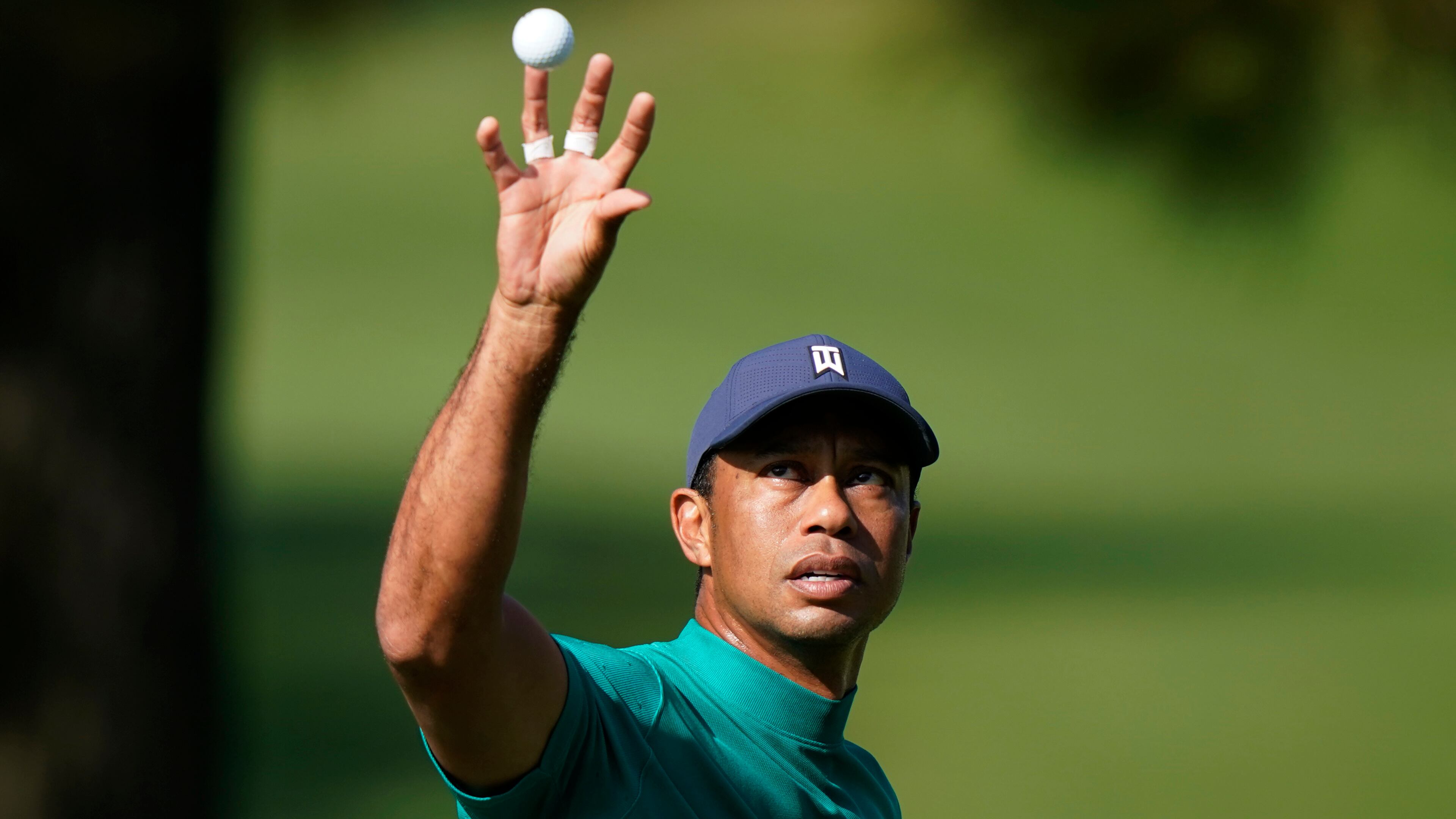 Tiger Woods catches a ball from his caddie at the practice range during a practice round for the Masters Tournament Monday, Nov. 9, 2020, in Augusta, Ga. (David J. Phillip/AP)