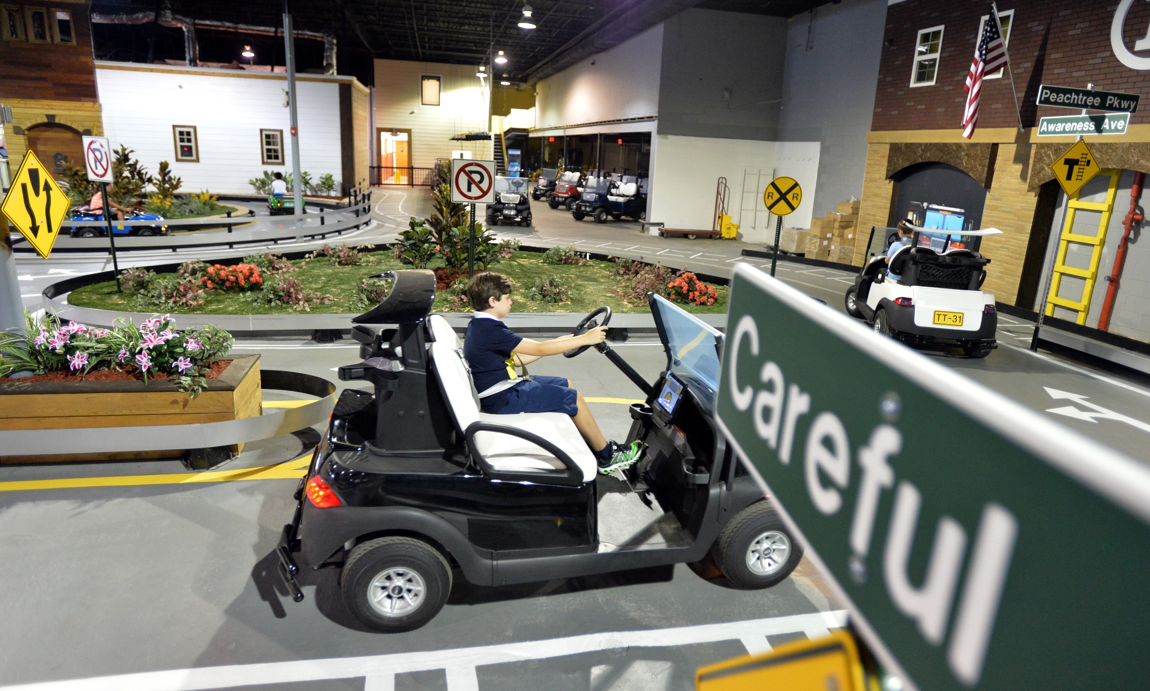 Children learn to respect road signs and other drivers July 8, 2014 at Tiny Towne in Norcross. The facility introduces children ages 3 and older to real-life driving experiences and helps them steer away from dangerous, reckless driving.