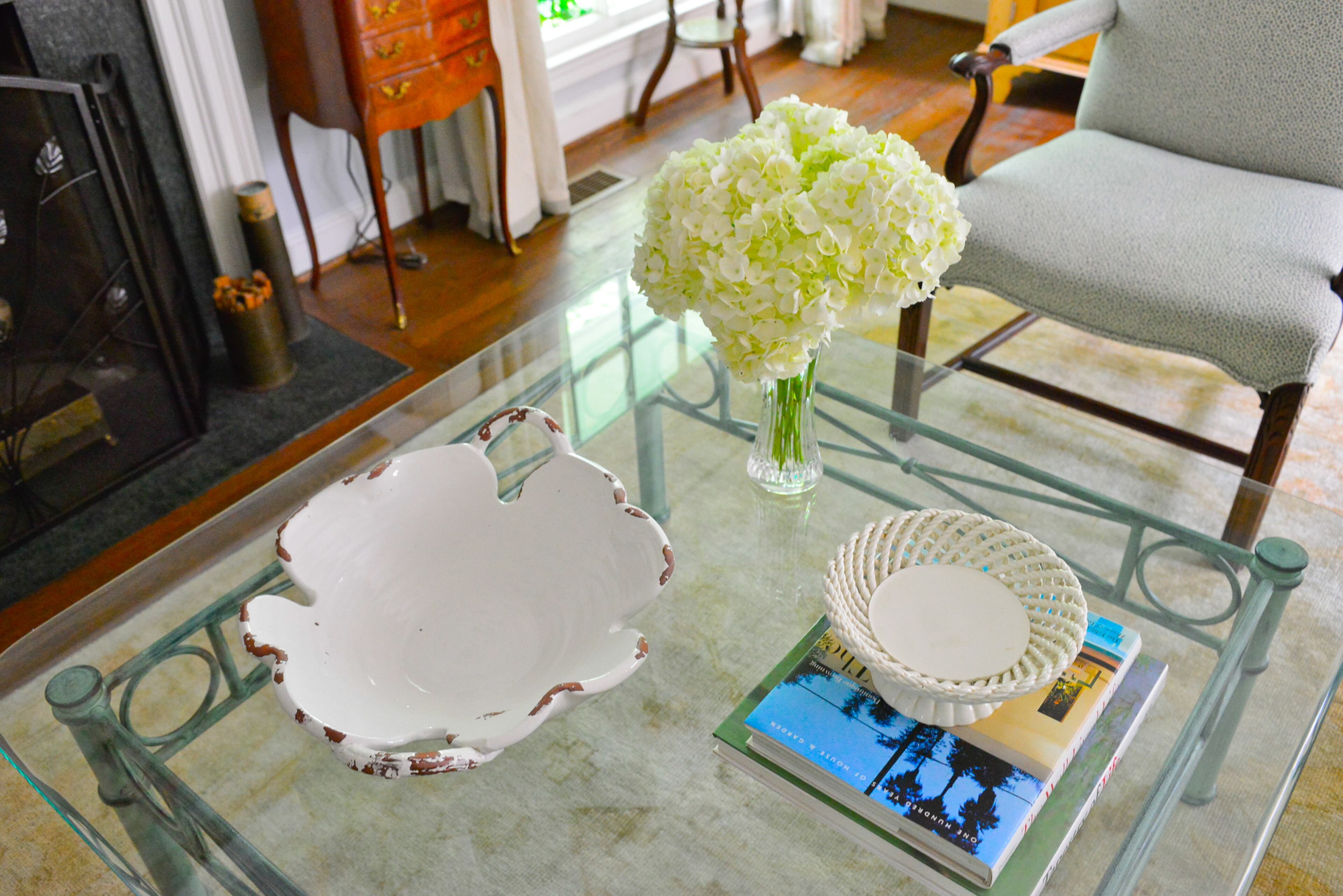 The glasstop coffee table with iron legs is a more contemporary piece, set between two wingback chairs that the homeowners purchased at an estate and recovered. You can see the rug from Surya - hand-knotted in India - through a glass table the homeowners purchased at the Atlanta Decorative Arts Center.