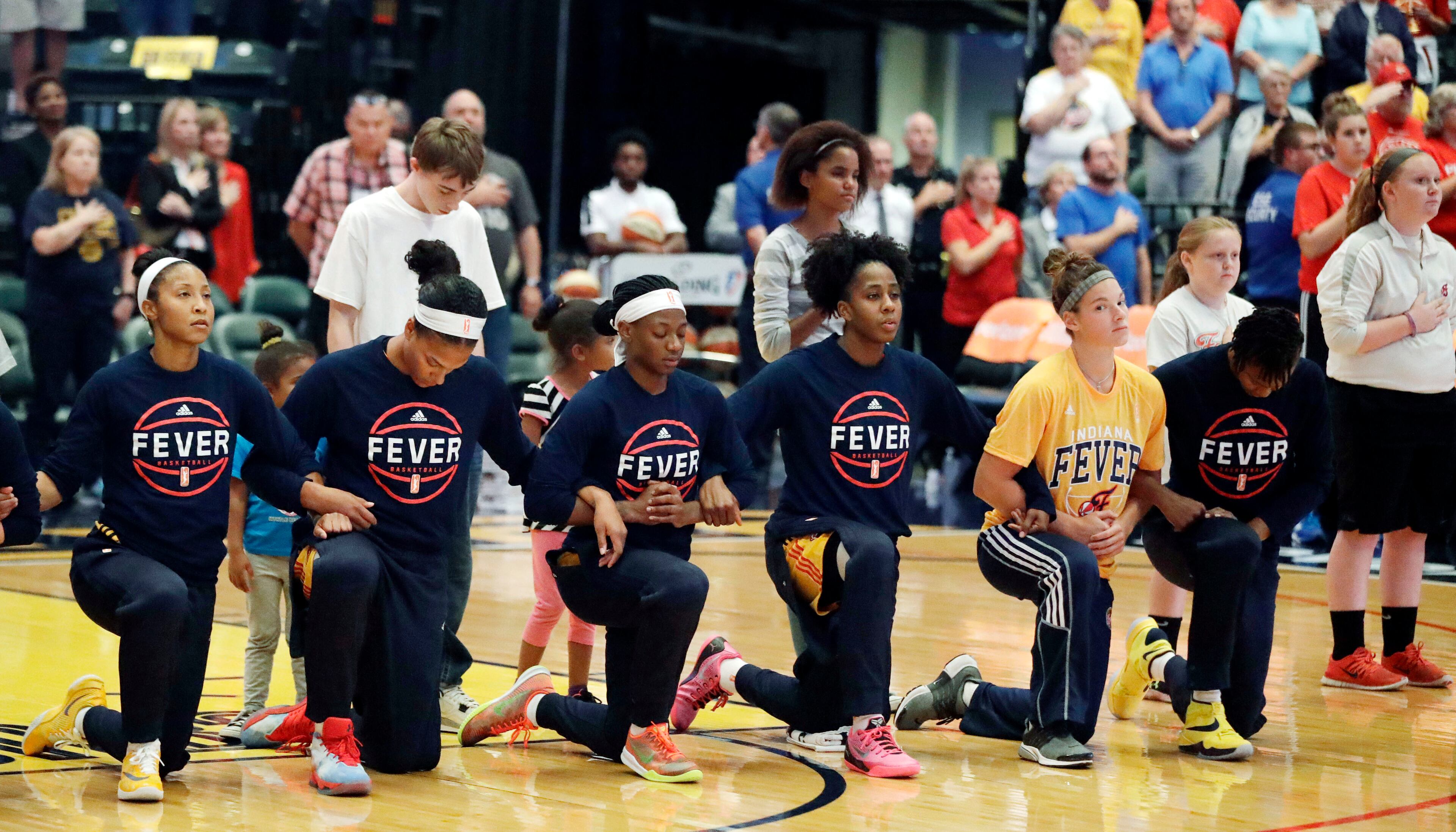 Members of the Indiana Fever kneel during the playing of the national anthem before the start of of a first round WNBA playoff basketball game, against the Phoenix Mercury, Wednesday, Sept. 21, 2016, in Indianapolis. (AP Photo/Darron Cummings)