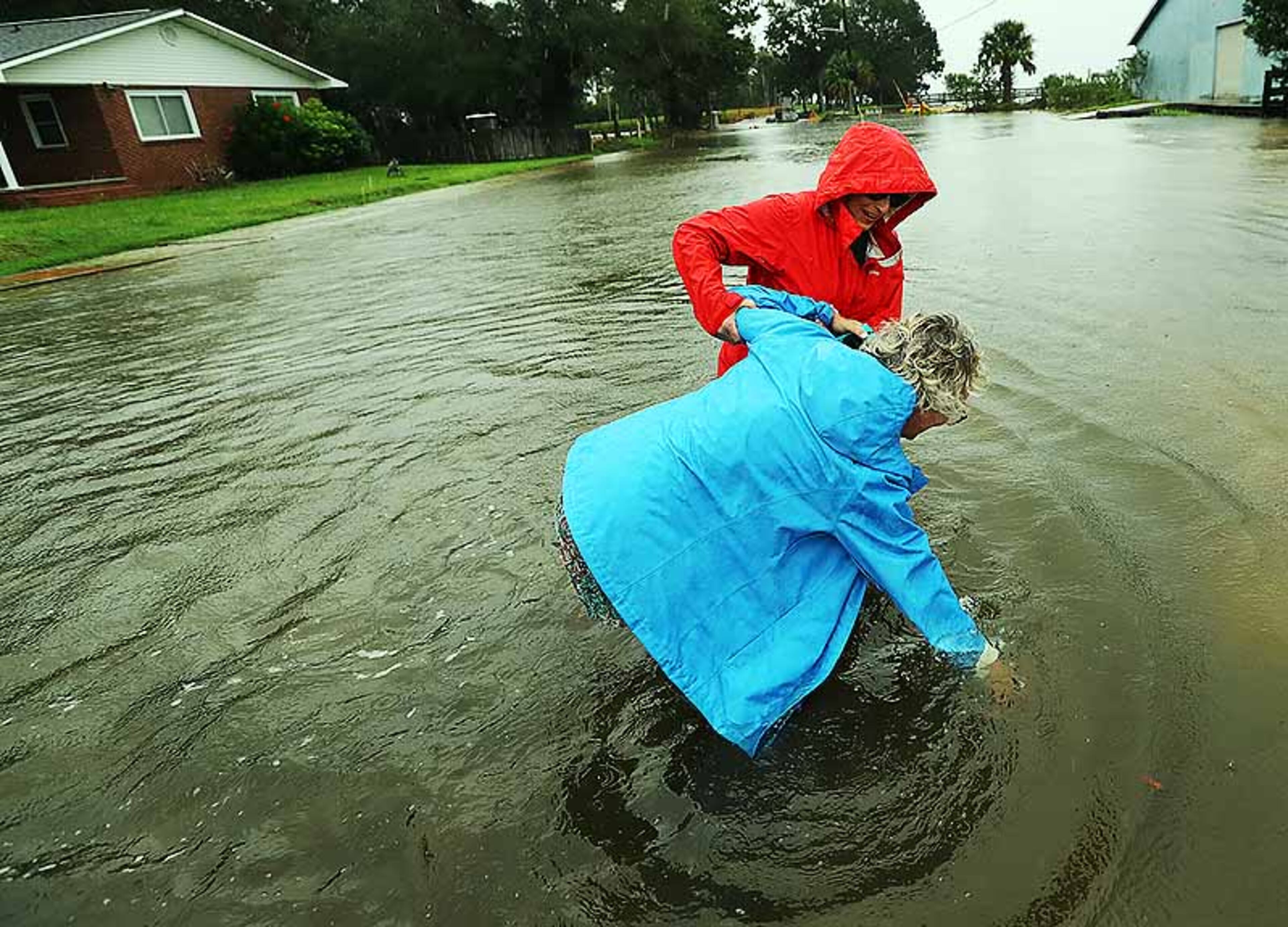 September 4, 2019 St. Mary's: Anne Herring (back) helps her friend Jen Fabrick (front) as she stumbles while walking through flood waters on St. MaryâÃôs Street while Hurricane Dorian passes by on Wednesday, Sept. 4, 2019, at St. Mary's. Curtis Compton/ccompton@ajc.com