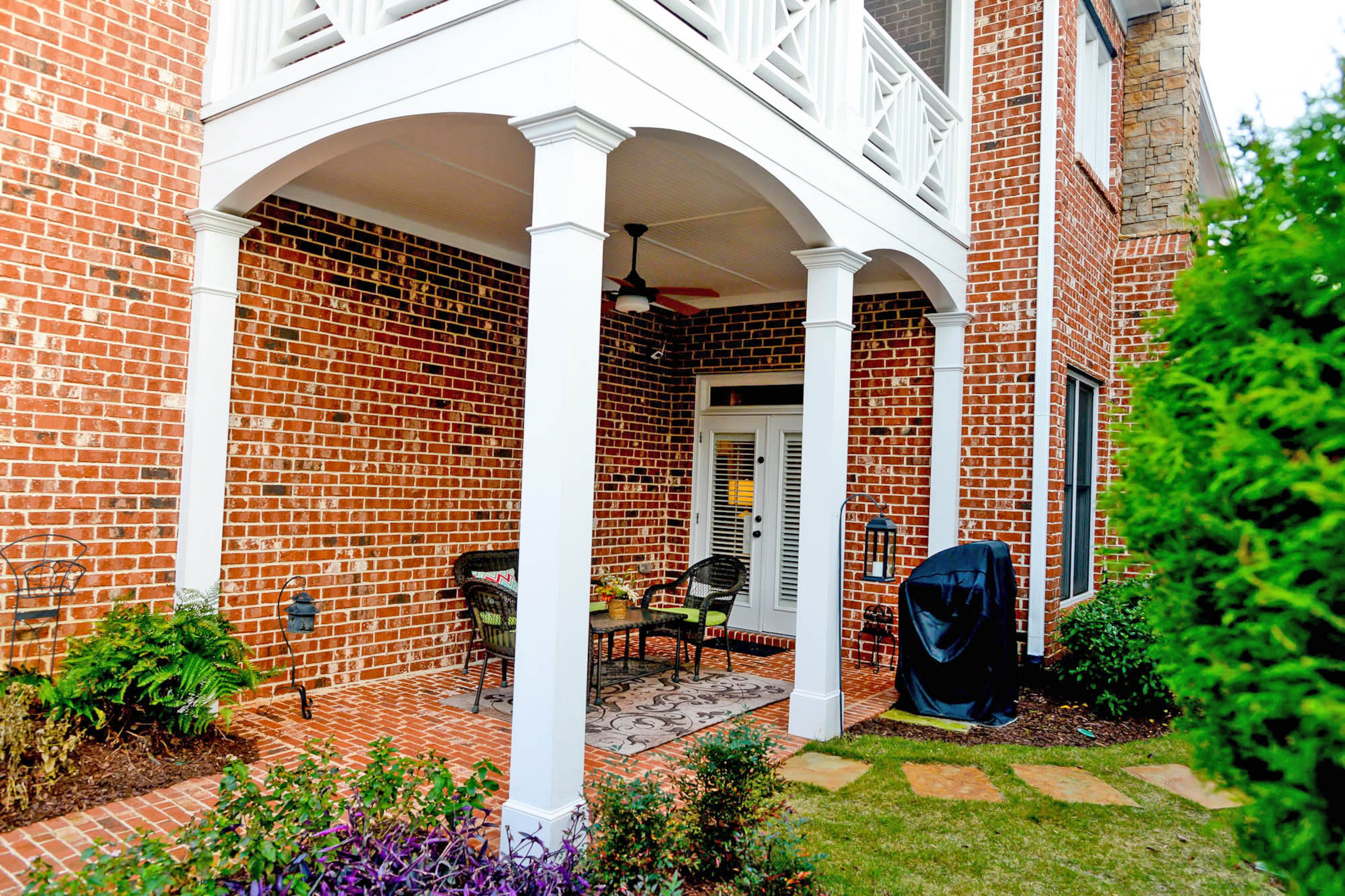 The outdoor spaces include a covered patio and porch off the second-story master bedroom. The brick Craftsman-style home was built by Monte Hewett Homes in 2002.