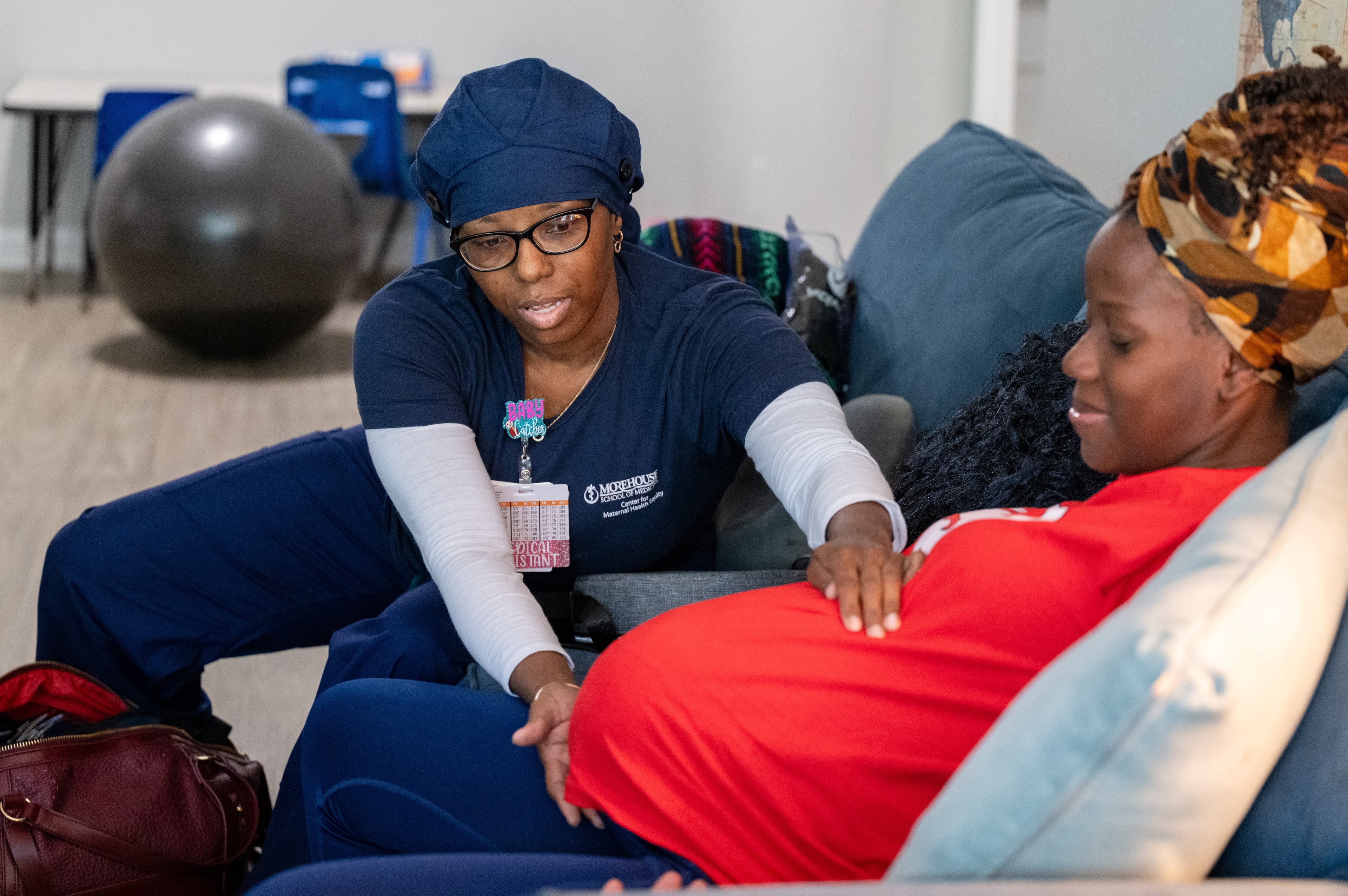 Doula Bashellia Williams (left) checks the position of her client, Reona Porter’s baby at Porter’s Stockbridge apartment on Friday, Oct. 8, 2024. Porter was just over 38 weeks pregnant. (Bita Honarvar for the AJC)