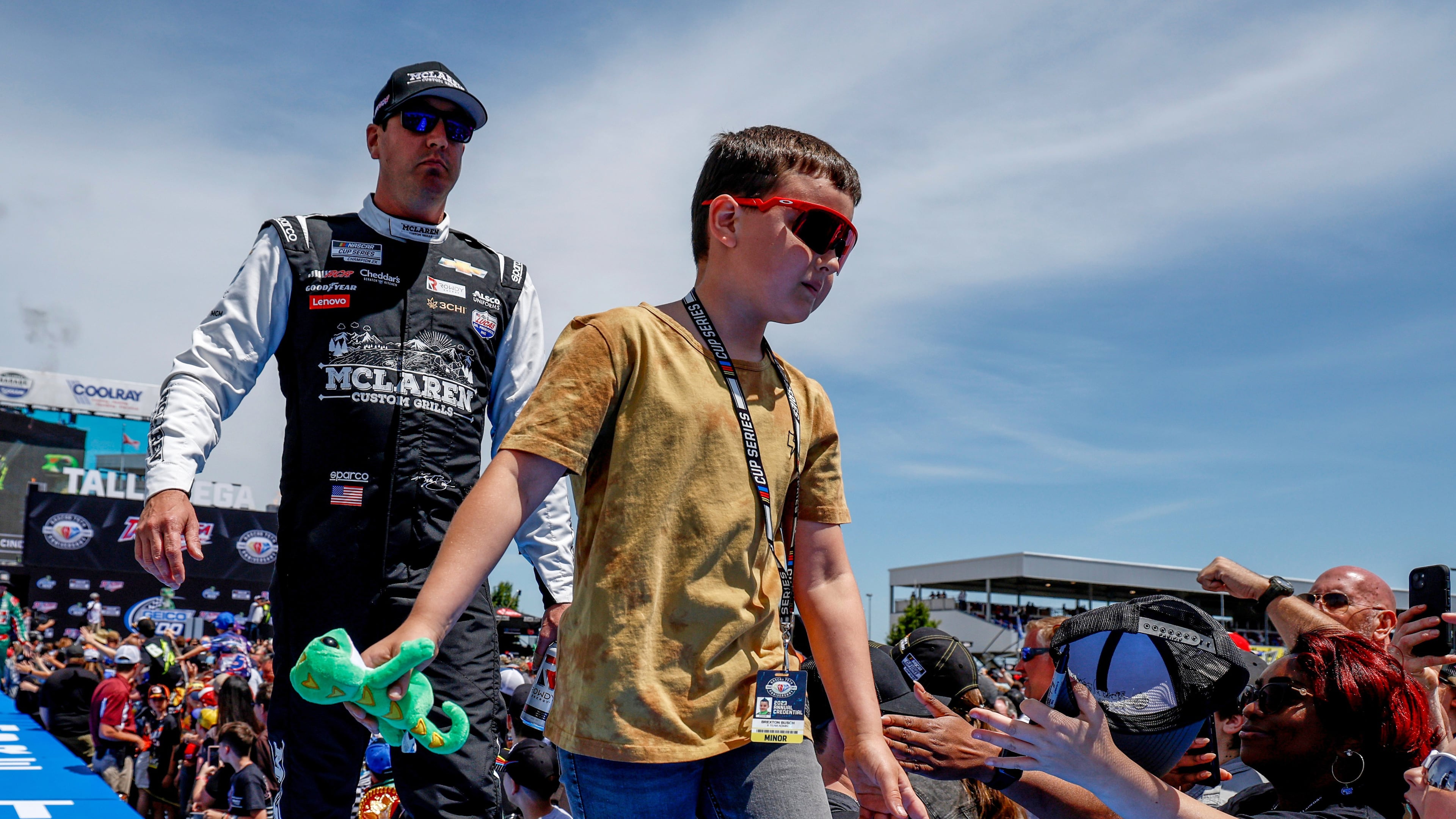 FILE - Kyle Busch, left, and his son greet fans before a NASCAR Cup Series auto race at Talladega Superspeedway, April 23, 2023, in Talladega, Ala. (AP Photo/Butch Dill, File)