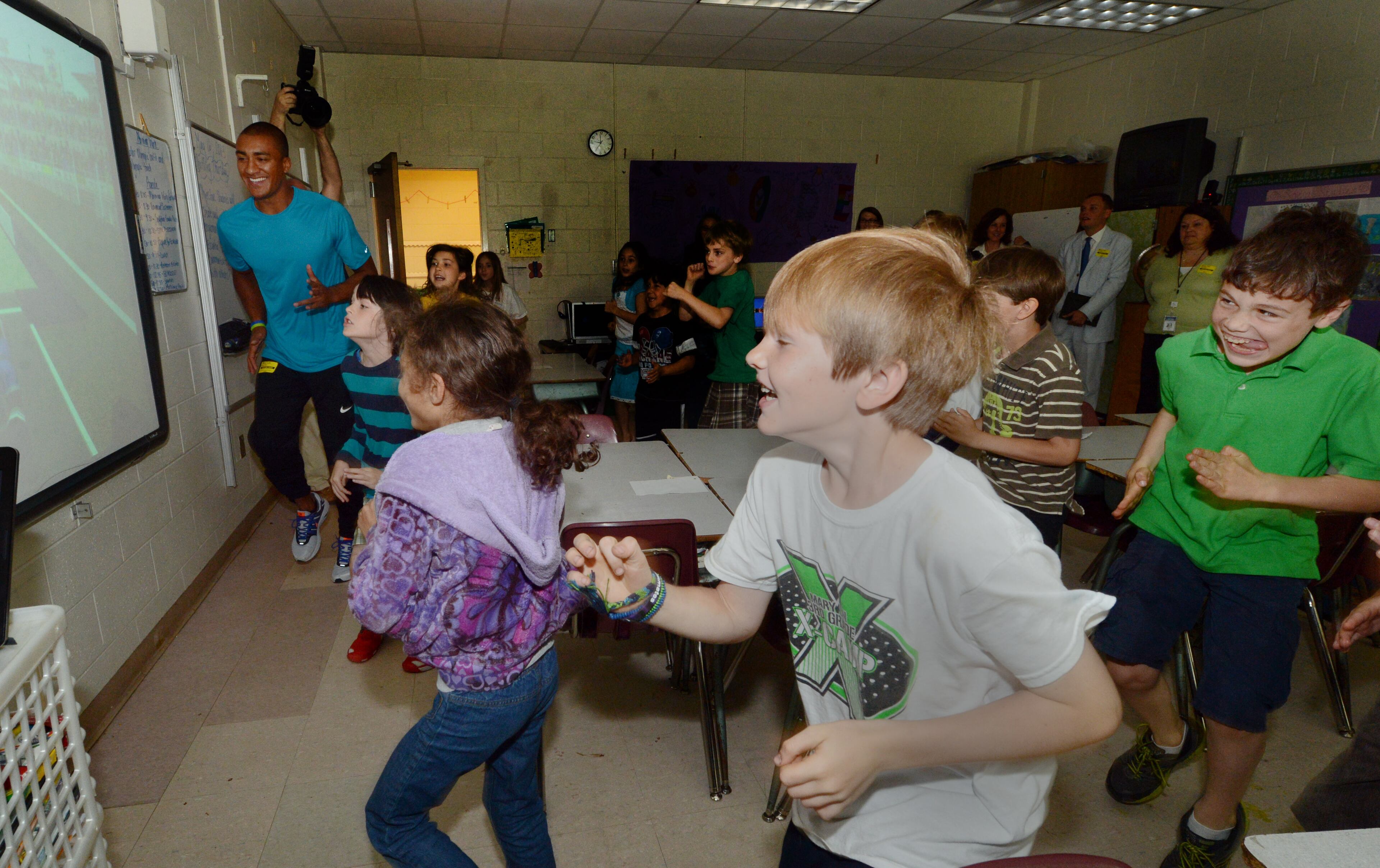 Olympic decathlon champion Ashton Eaton practices the long jump with third graders Arylka Derosa (from left), Skyler Cottrell, and Mark McClain at Mary Lin Elementary School.