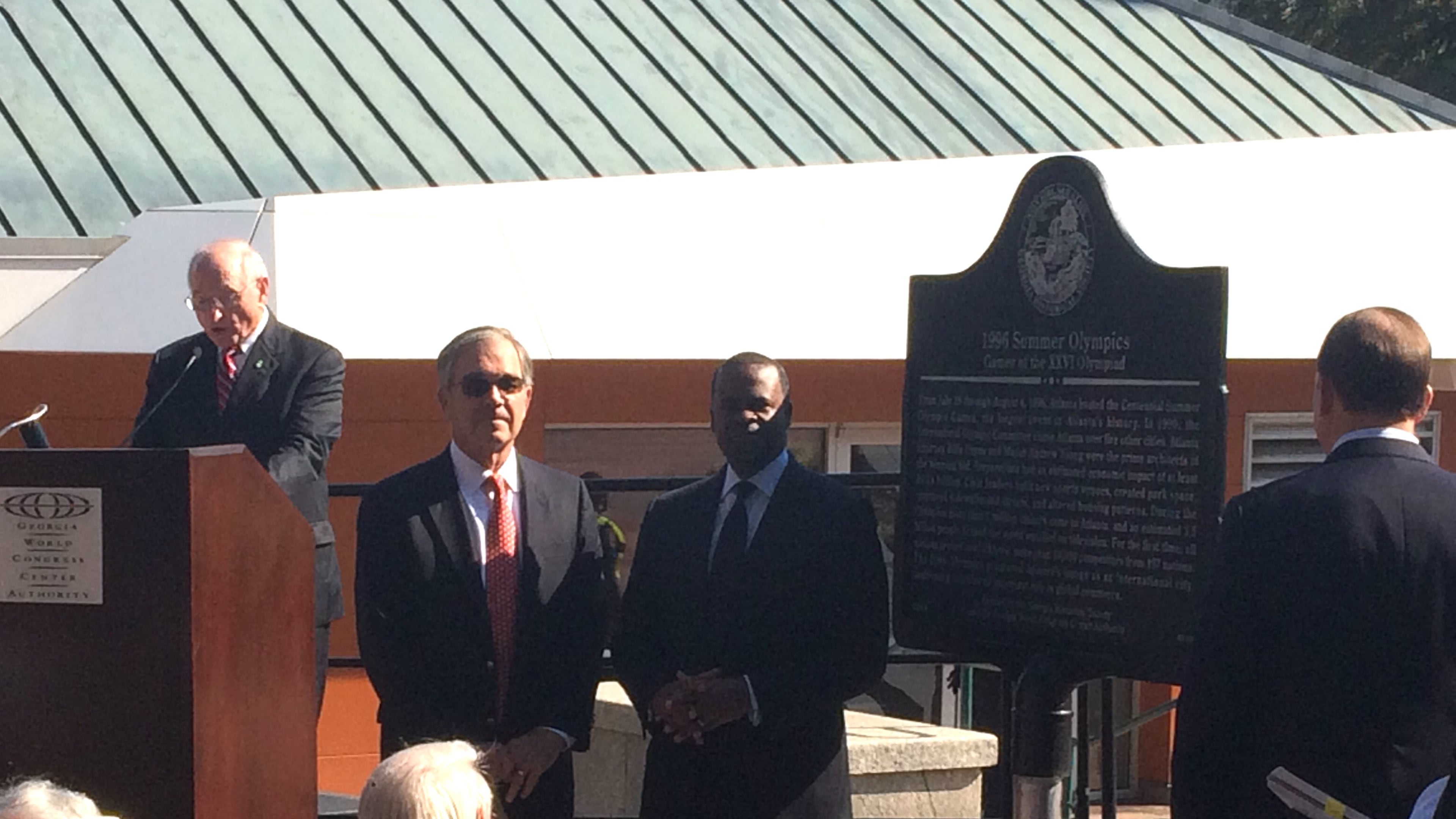 Former Atlanta Committee for the Olympic Games head Billy Payne and Atlantlocated a Mayor Kasim Reed listen to former UGA football coaching legend and Georgia Historical Society board member Vince Dooley at Tuesday mornings dedication of a historical marker to the 1996 Summer Olympics. The marker is near the visitor center in Centennial Olympic Park, the downtown gathering place that was built for the Games held in Atlanta. Photo by Jill Vejnoska