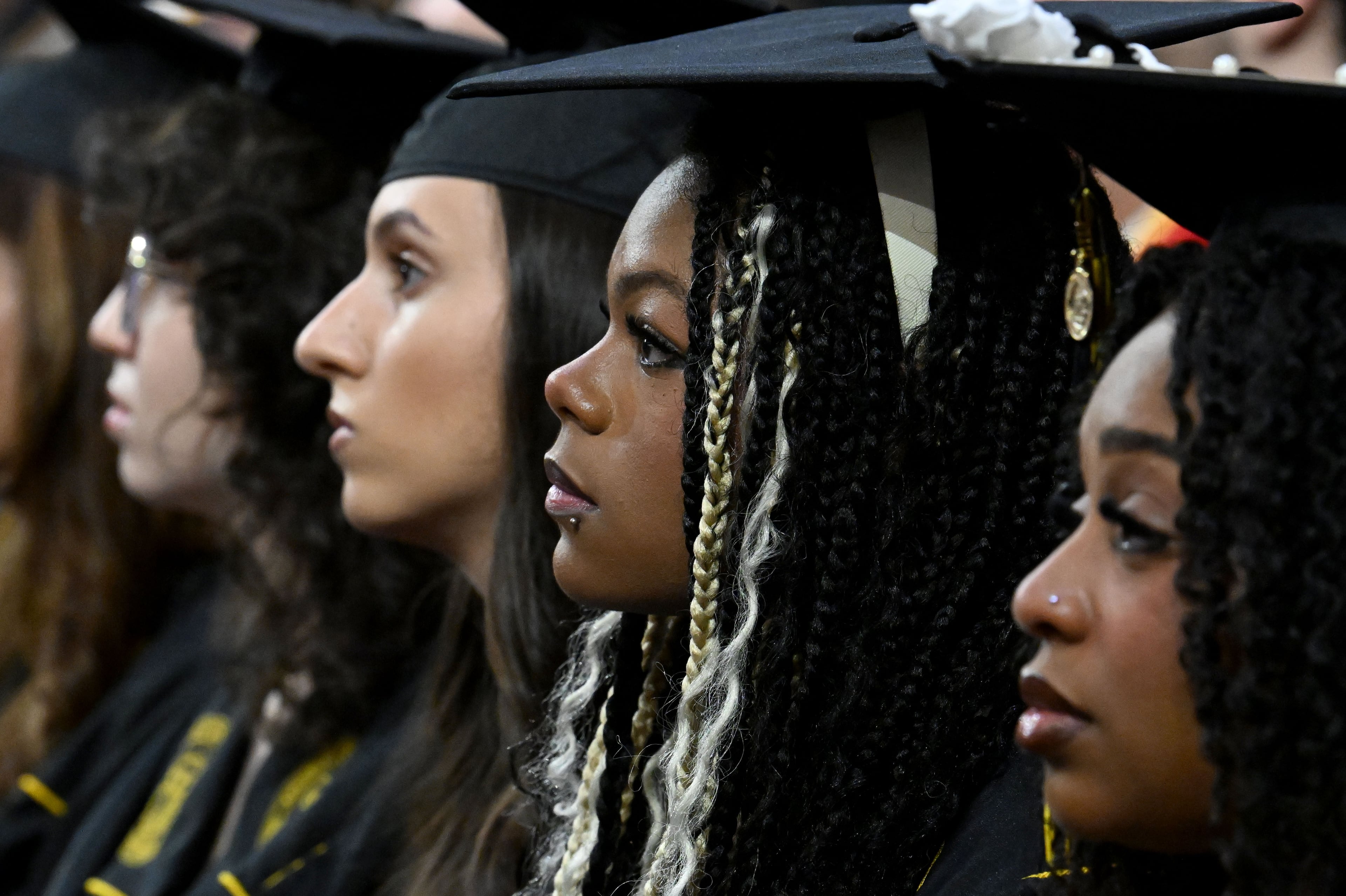 Graduates wait and listen to speakers before being able to move their tassle to the other side of their mortarboards. (Hyosub Shin/AJC)