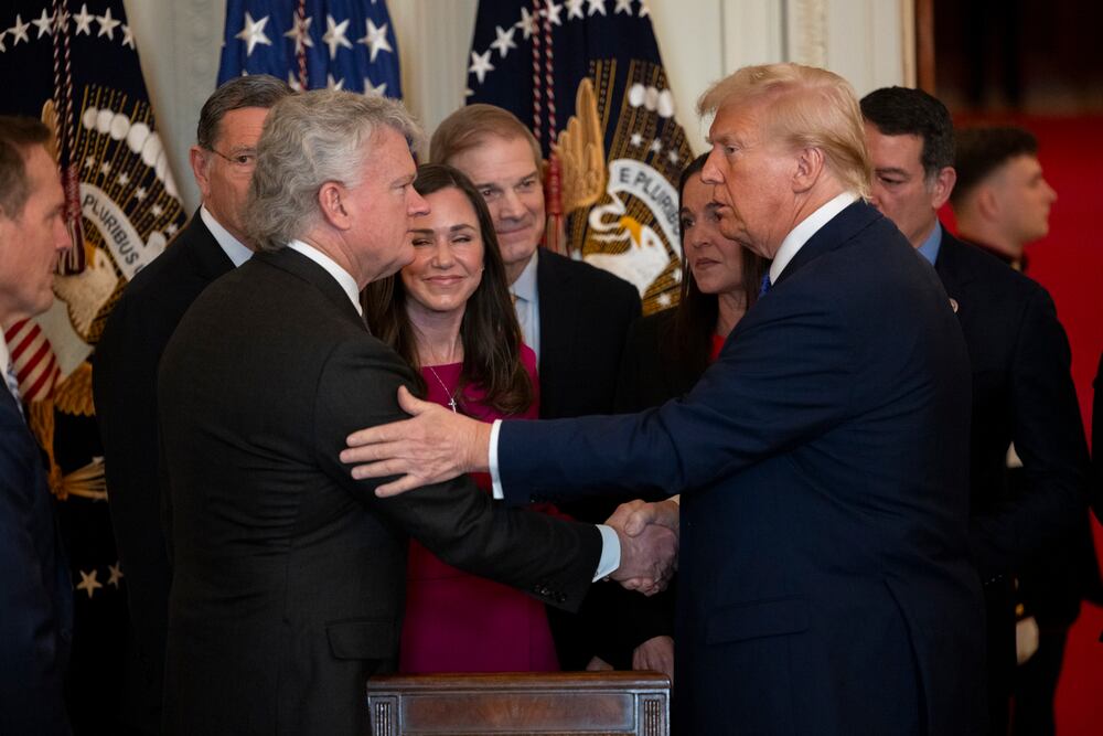 President Donald Trump (right) shakes hands with U.S. Rep. Mike Collins, R-Jackson, after signing the Laken Riley Act in the East Room of the White House in January 2025. (Nathan Posner for the AJC)