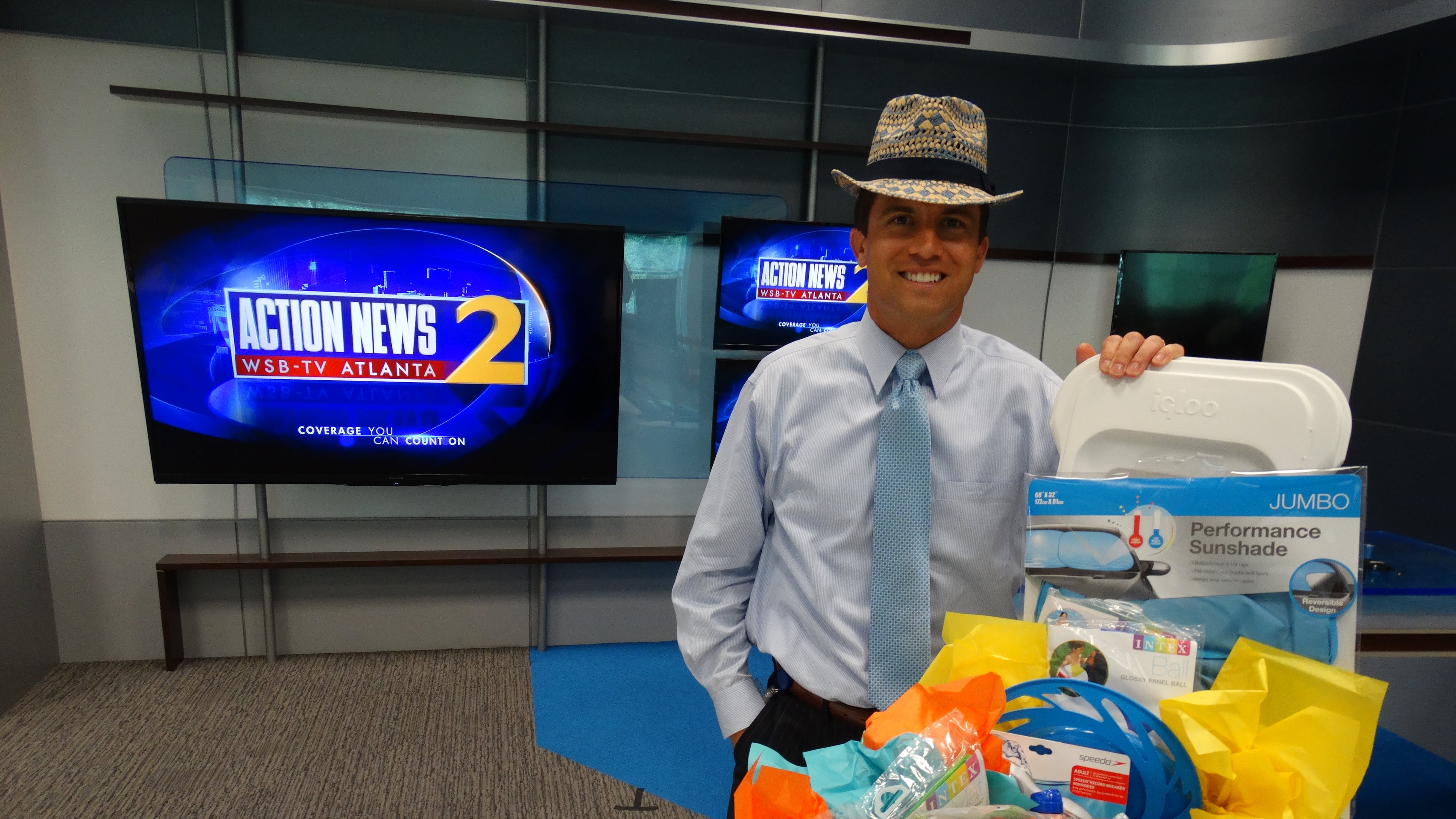 John Bachman on his last day at Channel 2 Action News today with some parting beach-related gifts. CREDIT: Rodney Ho/rho@ajc.com