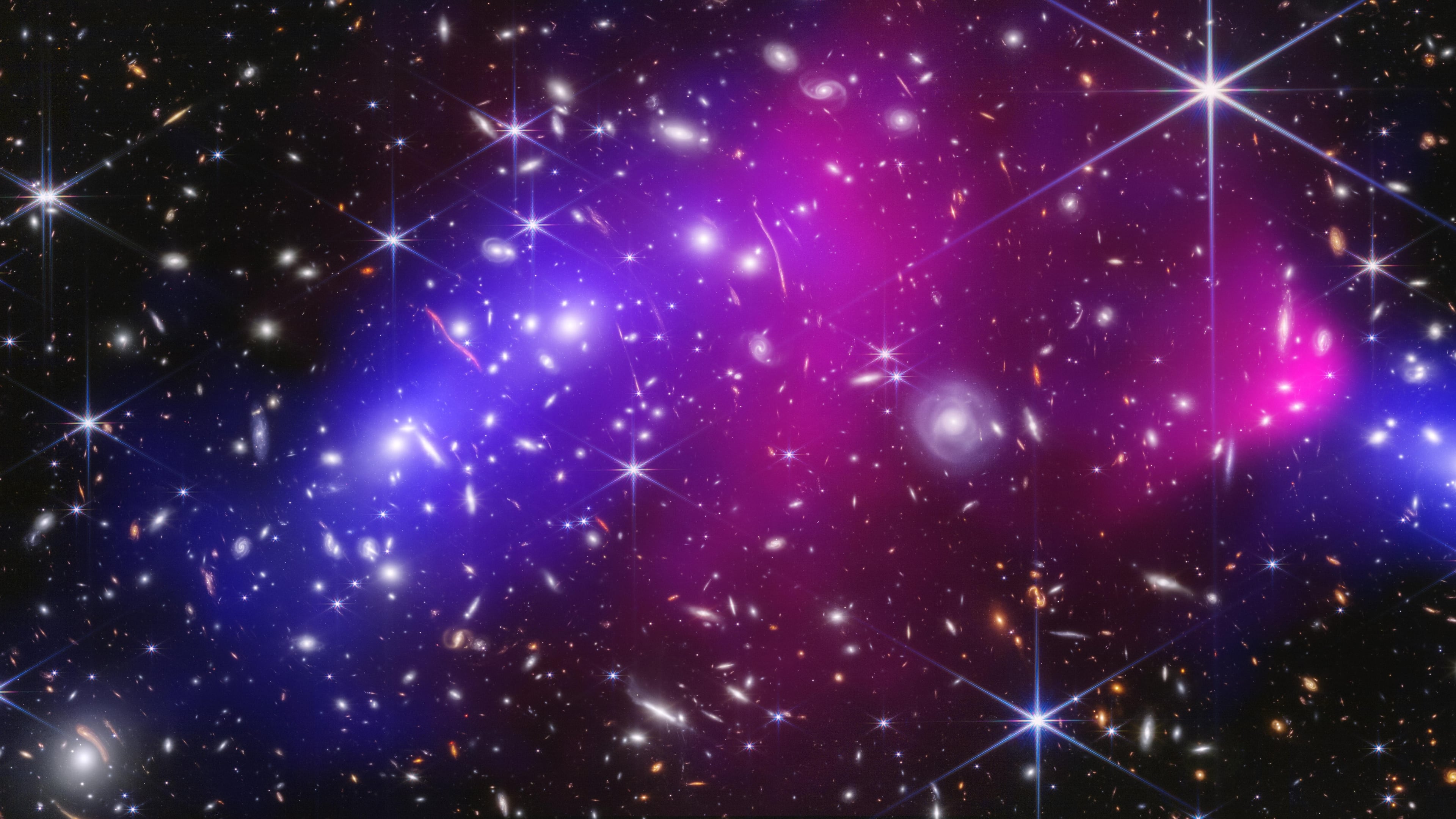 This NASA image shows two massive galaxy clusters previously captured by NASA's James Webb Space Telescope and Chandra X-ray Observatory, with areas of possible dark matter in blue. (NASA via AP)