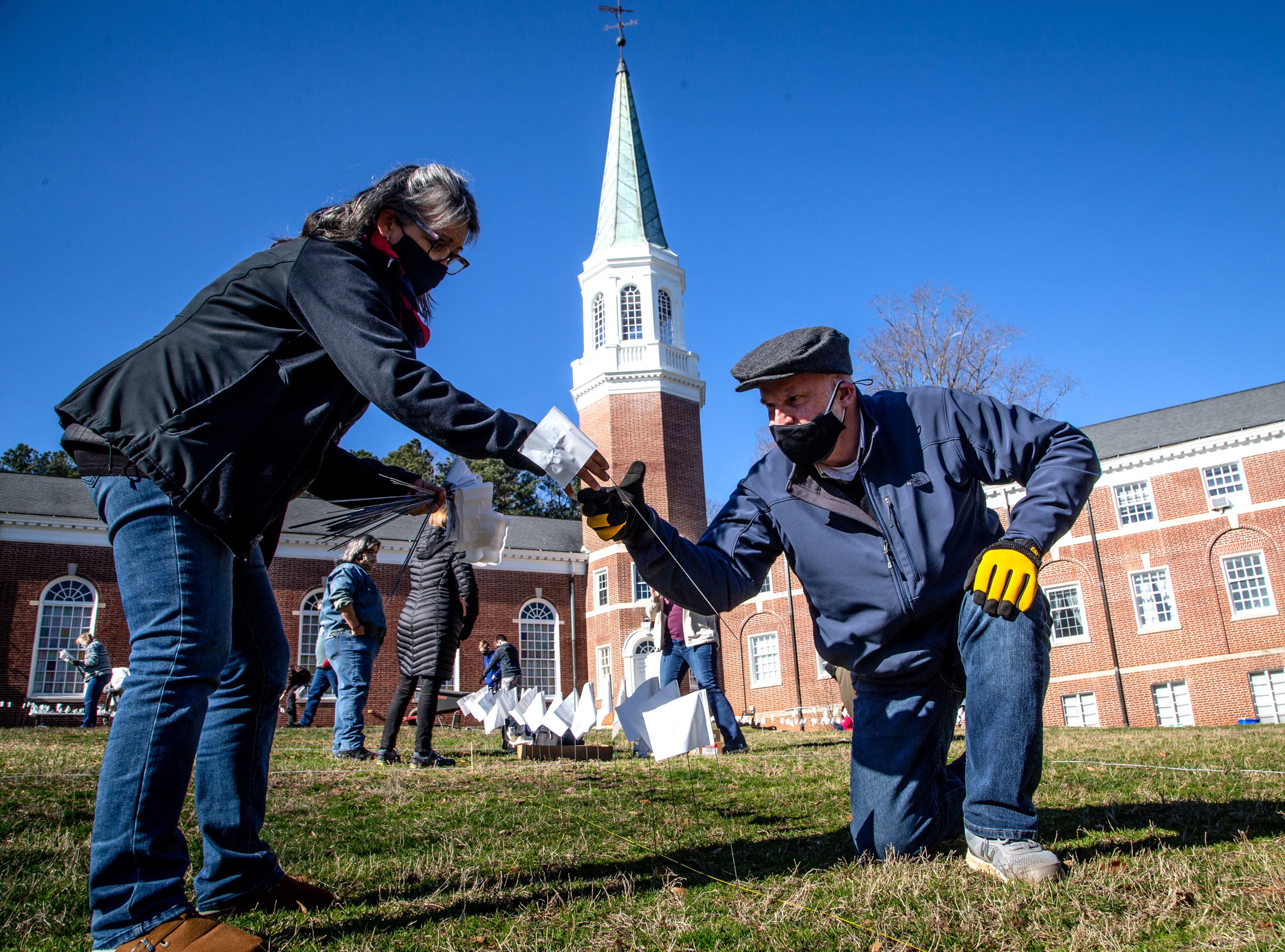 Mark Green (right) and Rhonda Brodie plant some of the 15,000 flags on the lawn of First Christian Church of Decatur on Saturday, February 20, 2021. The flags represent the number of COVID-19 deaths in Georgia, and the effort aims to raise awareness about the toll of the coronavirus. (Photo: Steve Schaefer for The Atlanta Journal-Constitution)