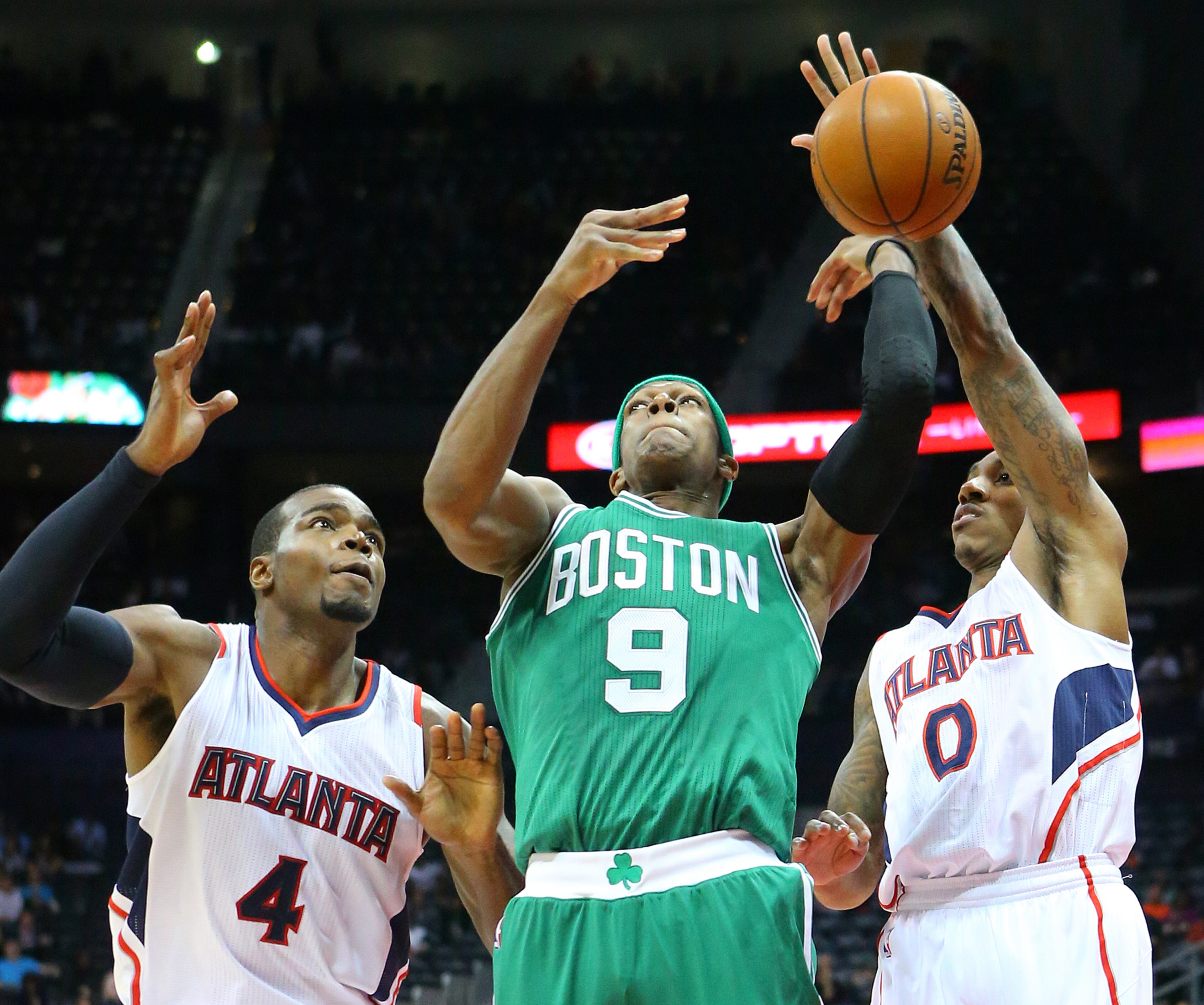 Hawks Paul Millsap (left) and jeff Teague defend against Celtics Rajon Rondo under the basket during the first half in an NBA basketball game on Tuesday, Dec. 2, 2014, in Atlanta. CURTIS COMPTON / CCOMPTON@AJC.COM