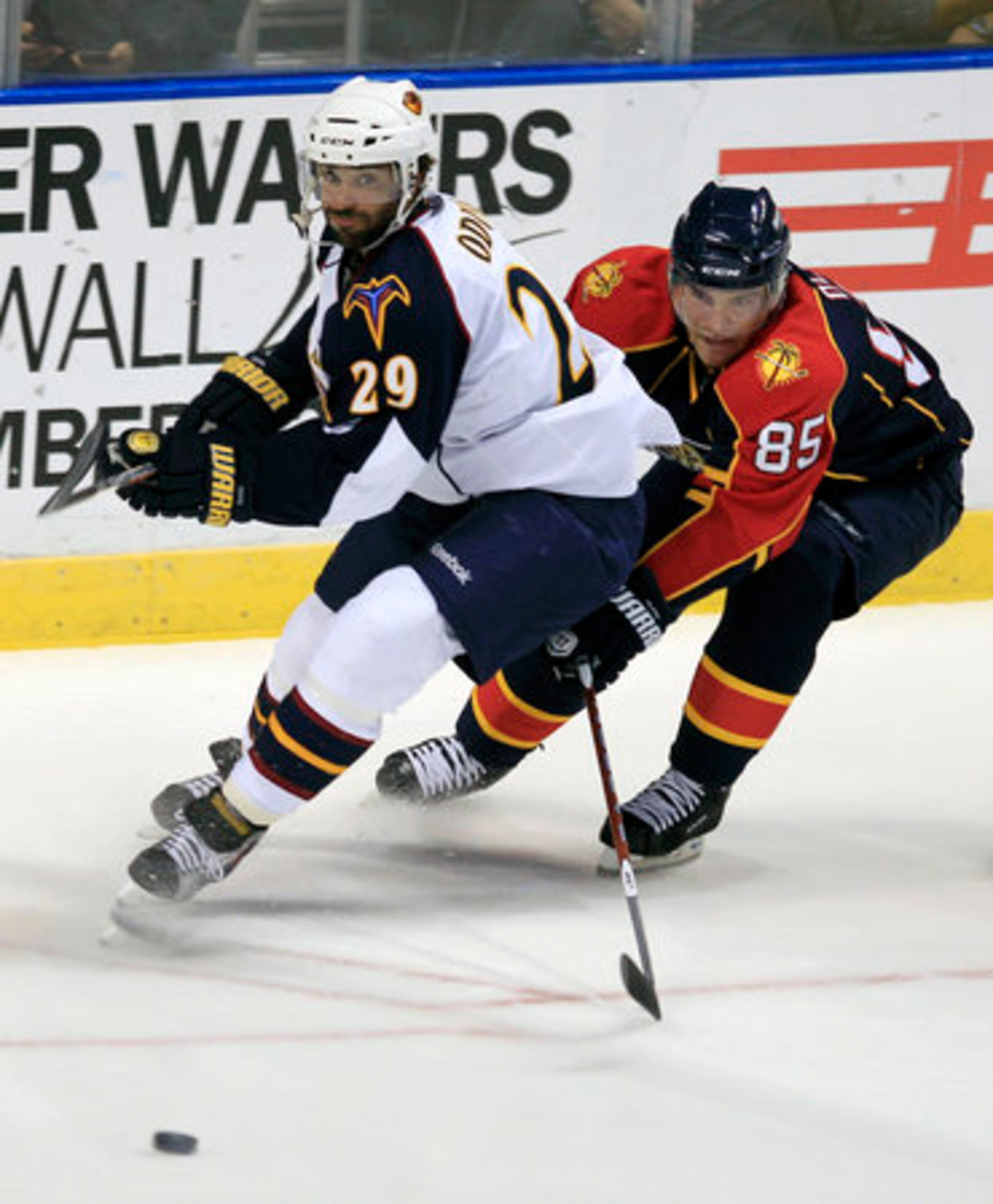 Atlanta Thrashers' Johnny Oduya (29) and Florida Panthers' Rostislav Olesz (85) battle for the puck during the first period of a NHL hockey game in Sunrise, Fla., Wednesday, Nov. 3, 2010.