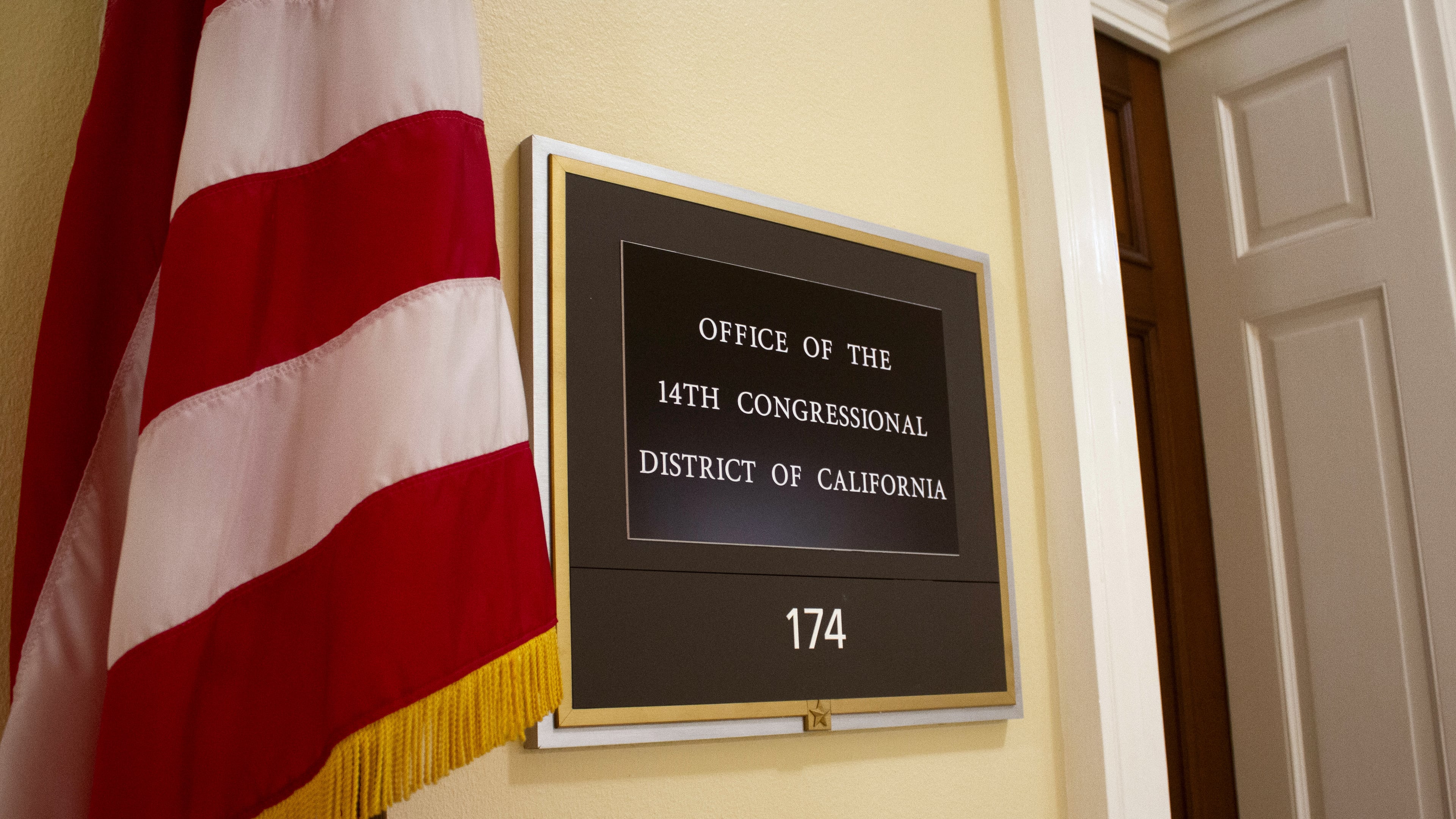 An American flag stands outside the office of California's 14th Congressional District in the Cannon House Office Building in Washington, Monday, July 20, 2026. (AP Photo/Tallulah Brown Van Zee)