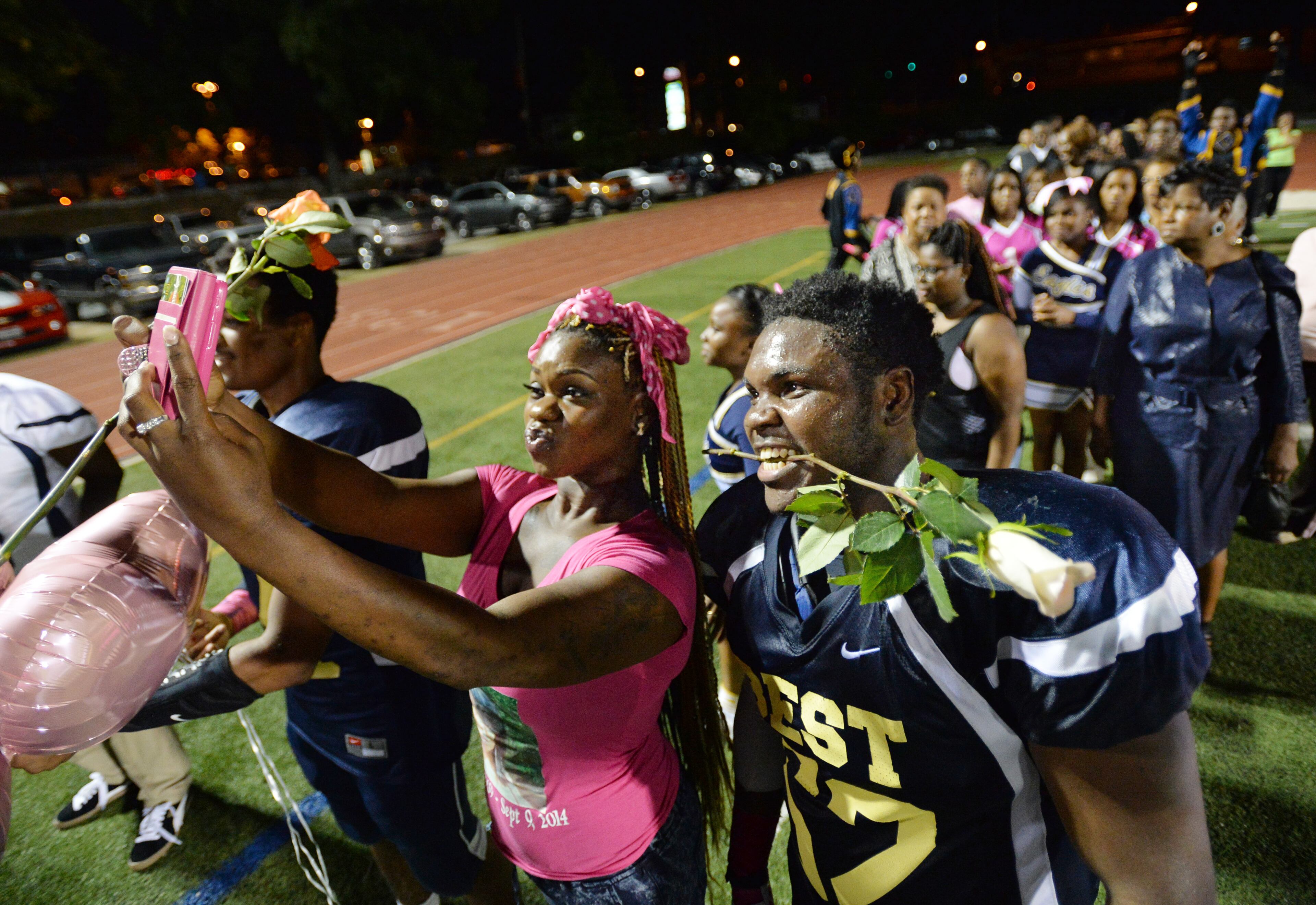 Darius Marshall, 18, and his sister Ashley Roberson, 23, pose for a photo as they wait to walk on the field for senior night event during their game against the Wesleyan school at Grady High School stadium on Friday, October 10, 2014. HYOSUB SHIN / HSHIN@AJC.COM