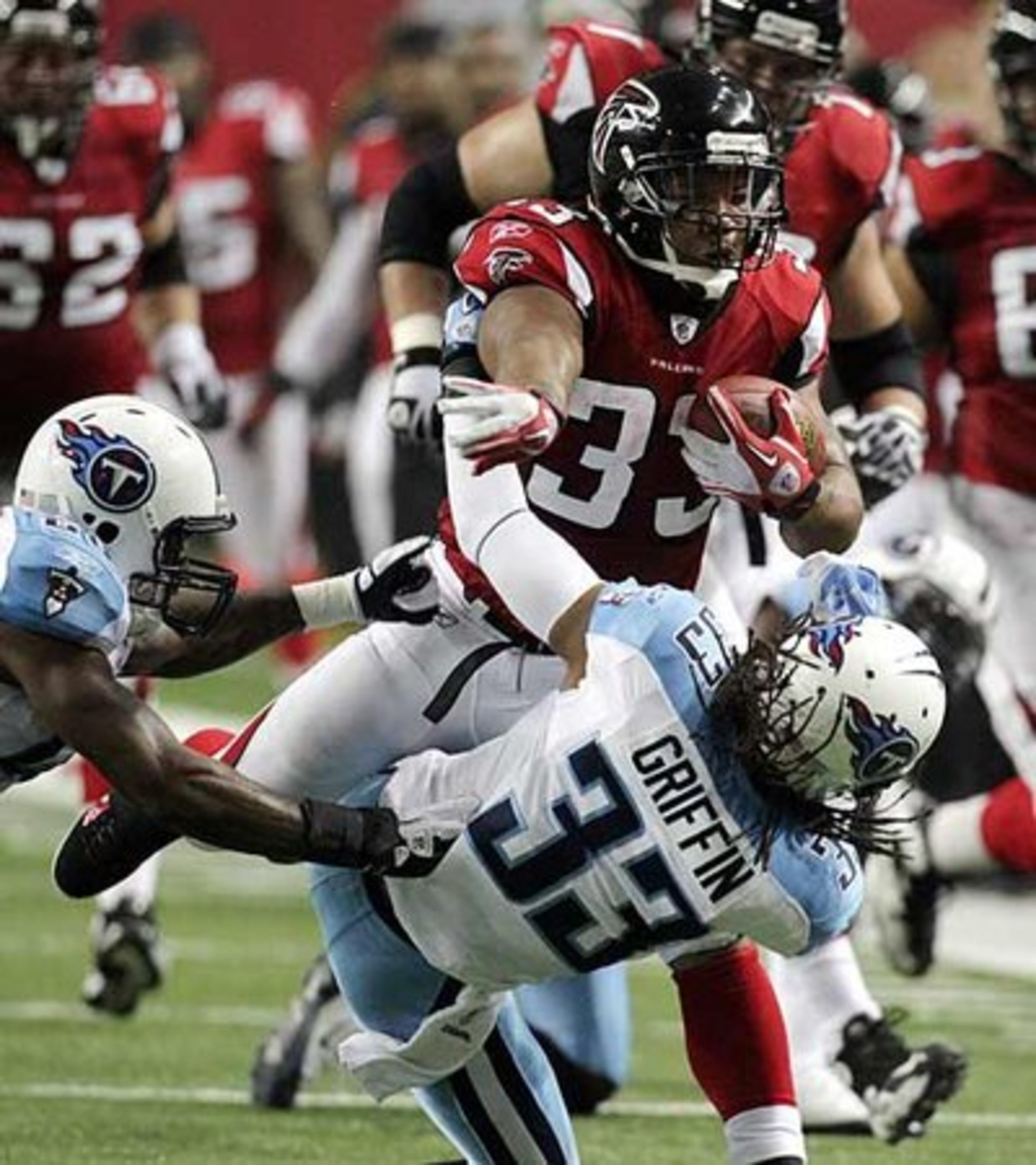 Falcons running back Michael Turner bowls over Tennessee Titans Michael Griffin as he bulls his way through the Titans for a long first down run during 2nd quarter action.