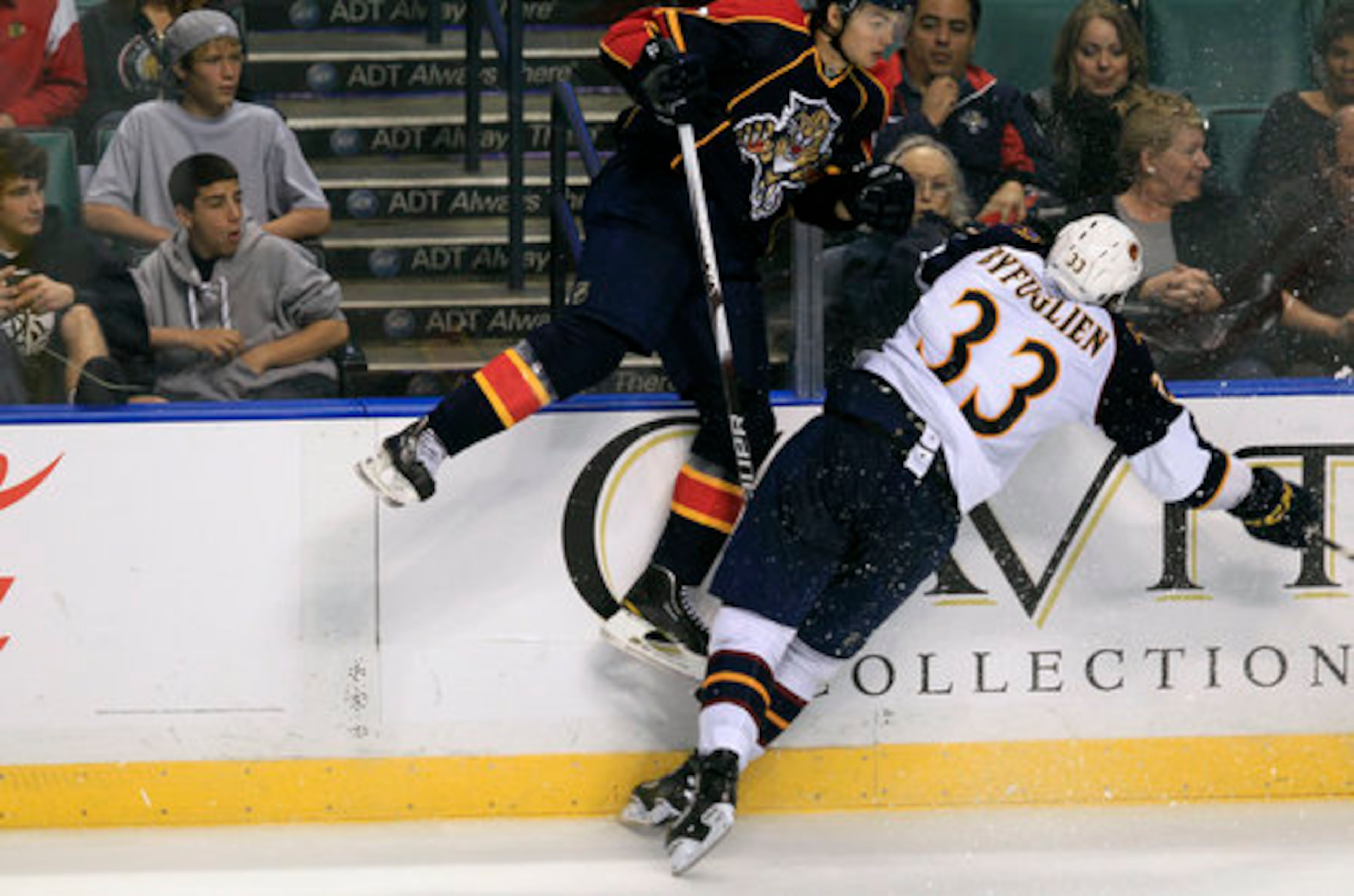 Florida Panthers' Michael Frolik, top, and Atlanta Thrashers' Dustin Byfuglien (33) slam into the wall during the second period of an NHL hockey game in Sunrise, Fla., Wednesday, Nov. 3, 2010.