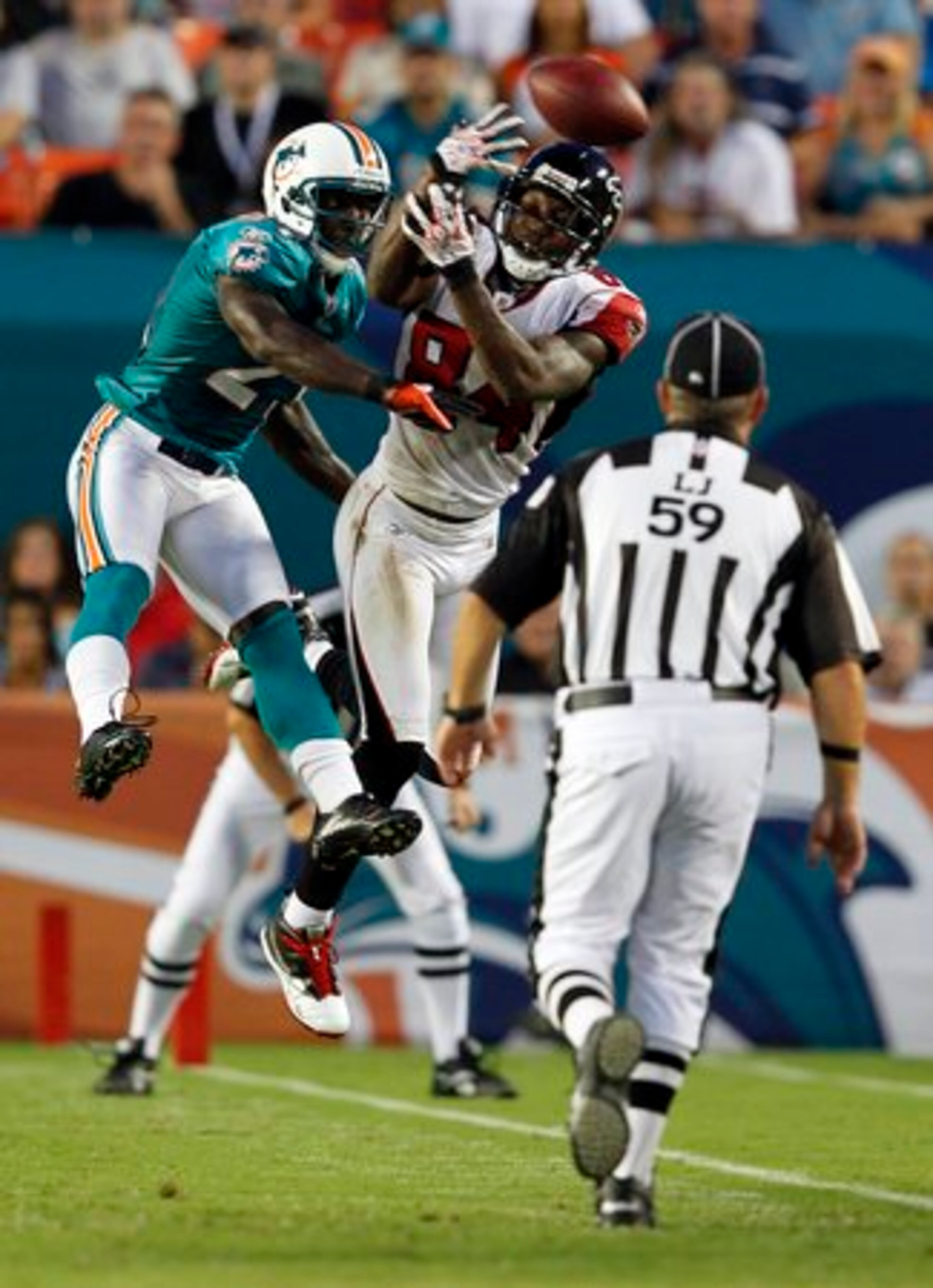 Miami Dolphins corner back Vontae Davie (21) and Atlanta Falcons wide receiver Roddy White (84) battle for an incomplete pass as game official Rusty Barnes watches during first quarter NFL preseason football action in Miami, Friday, Aug. 27, 2010.