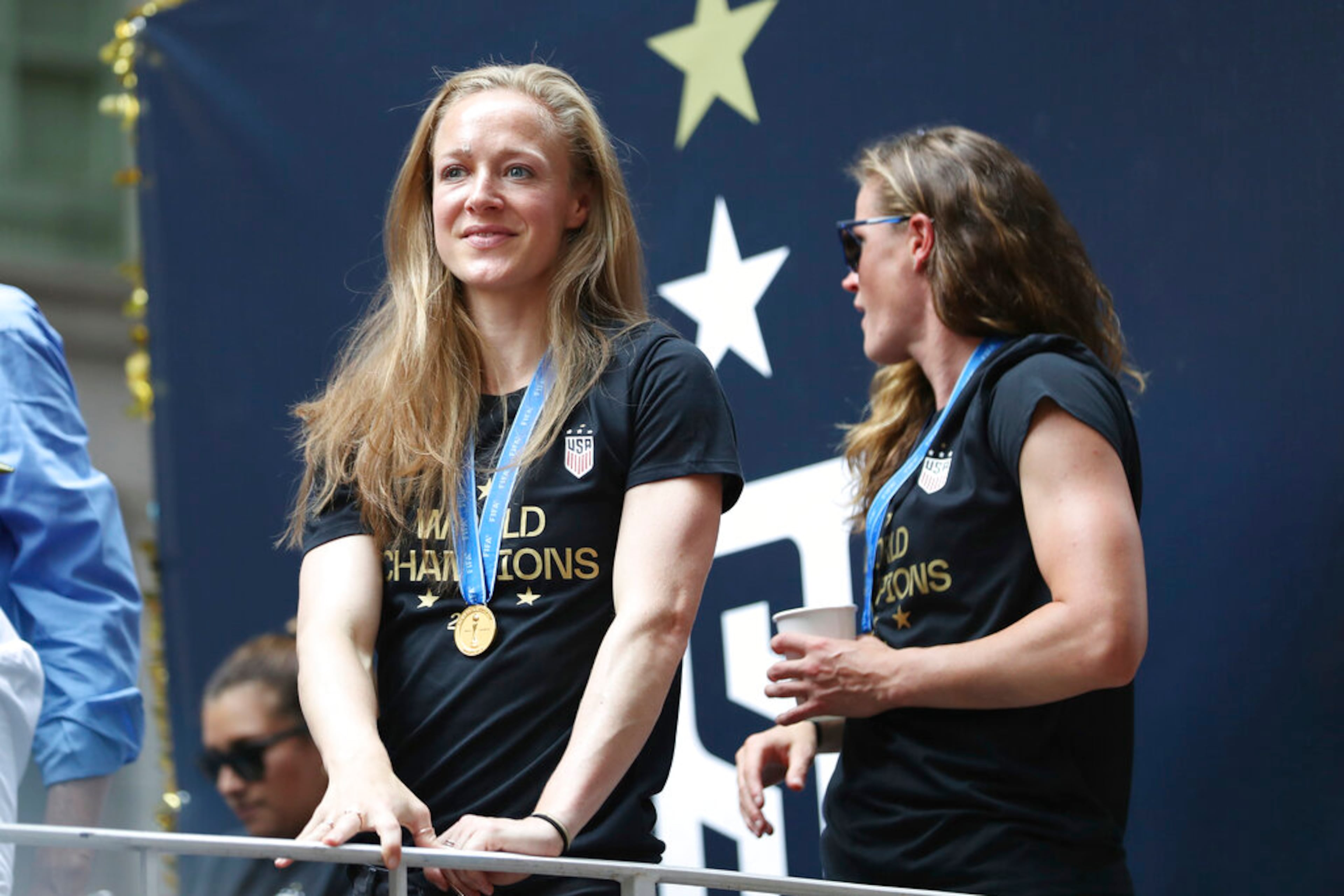 United States defender Becky Sauerbrunn, left, looks at the crowd on a float while being honored with a ticker tape parade along the Canyon of Heroes, Wednesday, July 10, 2019, in New York. The U.S. national team beat the Netherlands 2-0 to capture a record fourth Women's World Cup title. (AP Photo/Steve Luciano)