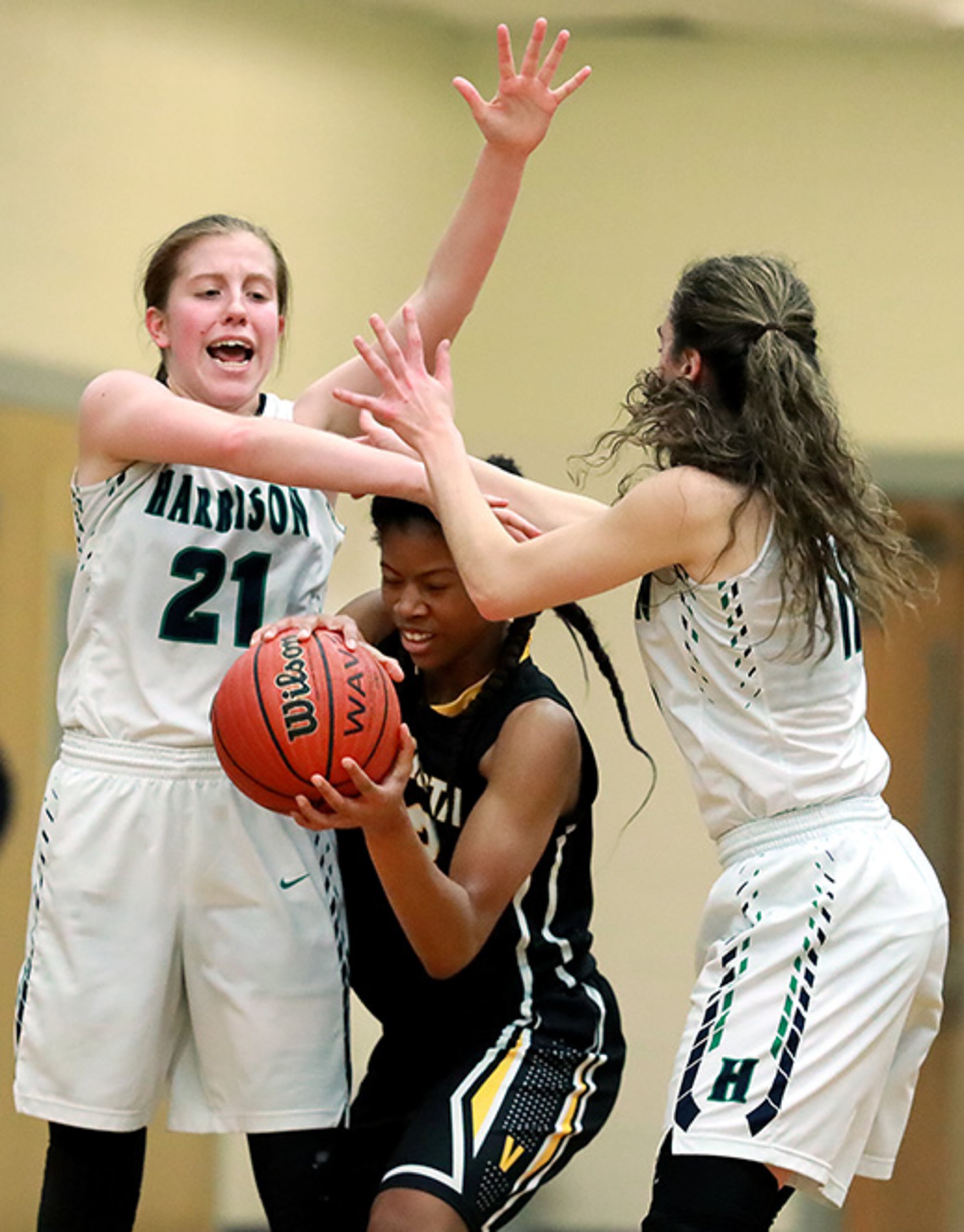 Harrison defenders Anna Gernatt (left) and Meredith Ward double team Valdosta's Nia Allen forcing a turnover in the Class AAAAAA quarterfinal high school girls basketball game at Harrison High School on Tuesday, Feb. 26, 2019, in Kennesaw.