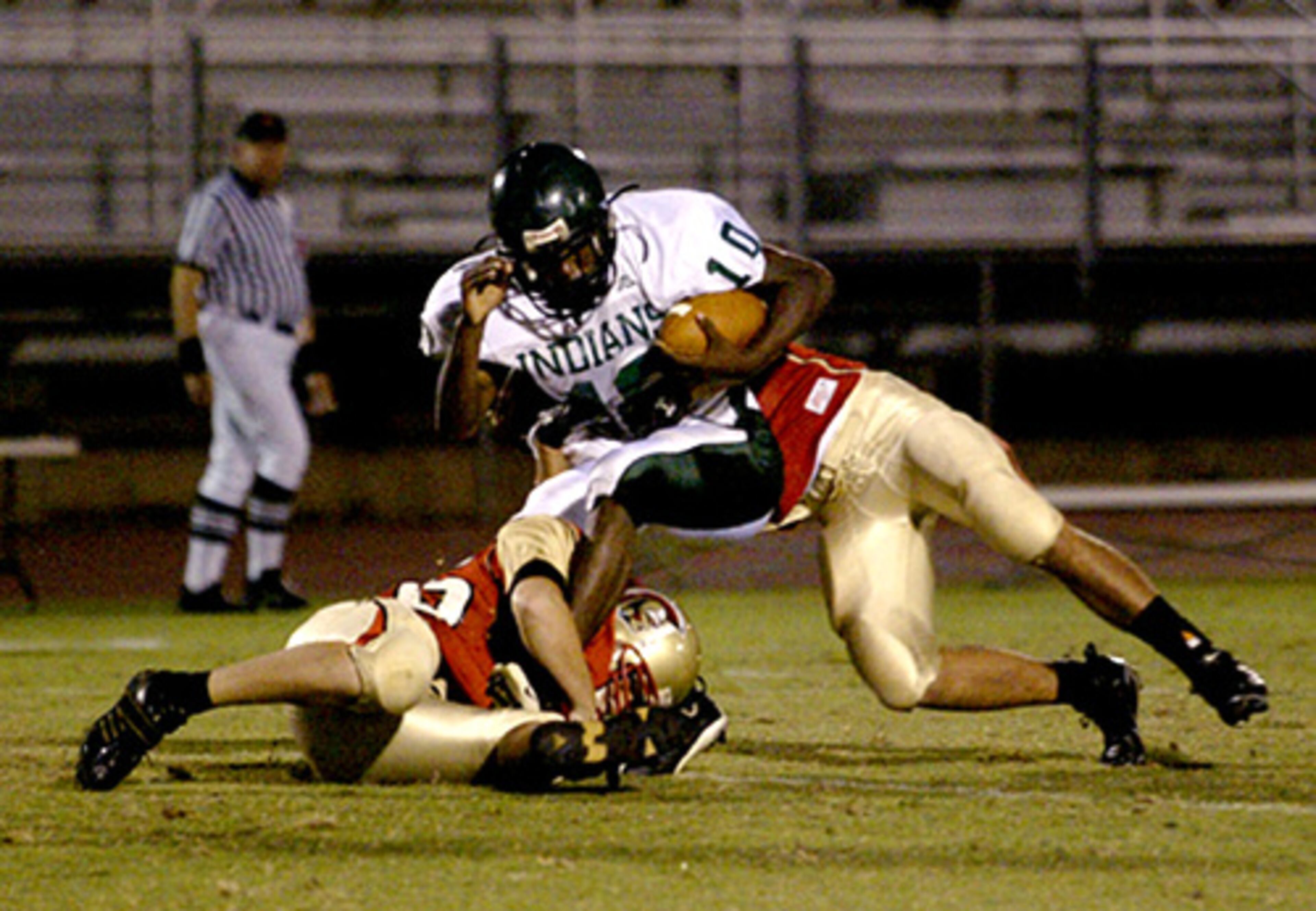 GAC's Sam Kessler (56, left) and Justin White (8, right) take down Cross Keys' Richard Feacher(10).
