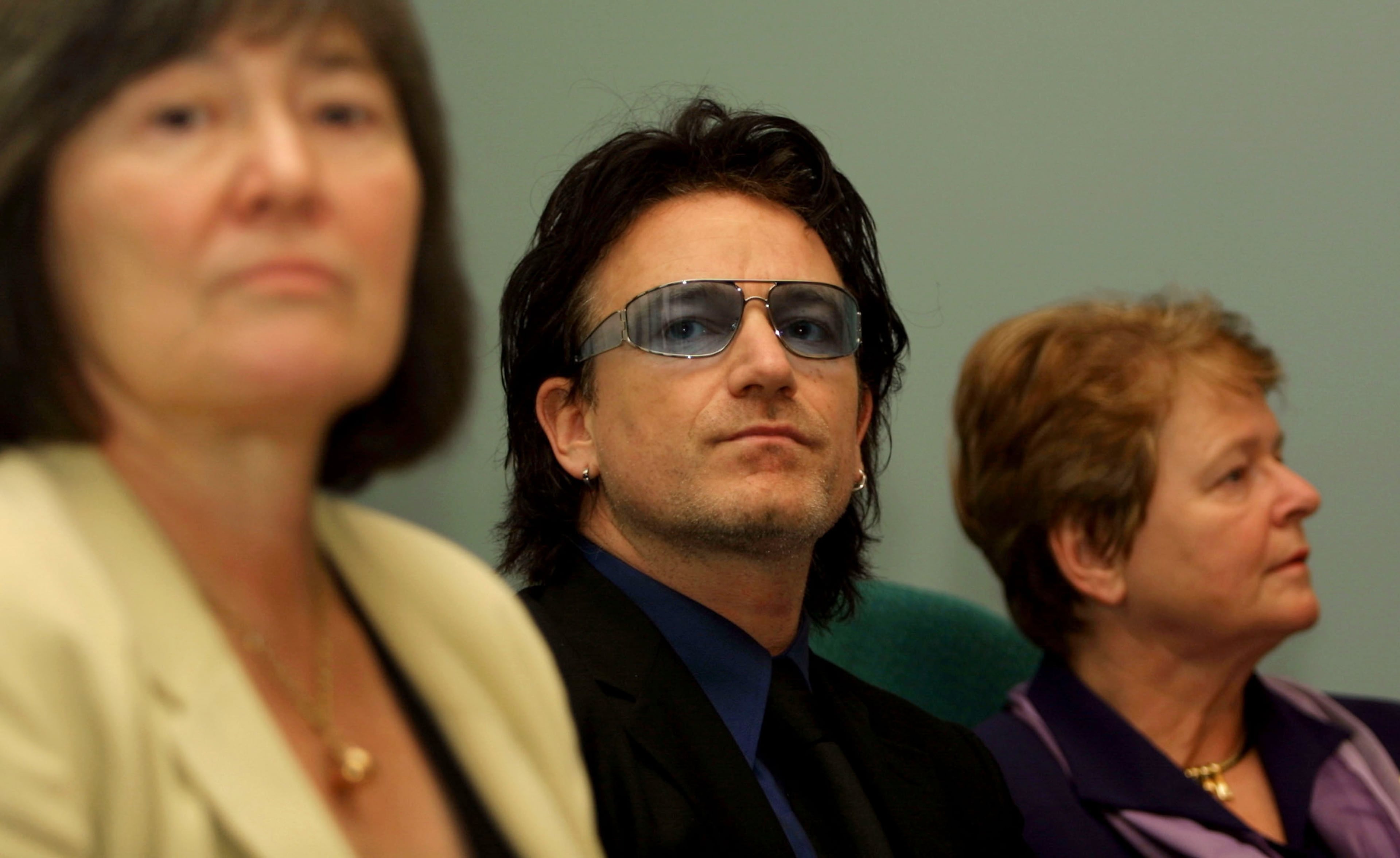 (L-R) Clare Short, the British Minister for Overseas Development, Bono, the lead singer of U2 and Dr. Gro Harlem Brundtland, the Director General of the World Health Organisation, listen to questions posed by journalists December 20, 2001 at the unveiling of a report, ''Macroeconomics and Health: Investing in Health for Economic Development'' in London. The report calls for major scaling up of investments in health for the poor by presenting scientific evidence that increased spending on health will promote development in poor countries and boost the global economy. (Photo by Sion Touhig/Getty Images)
