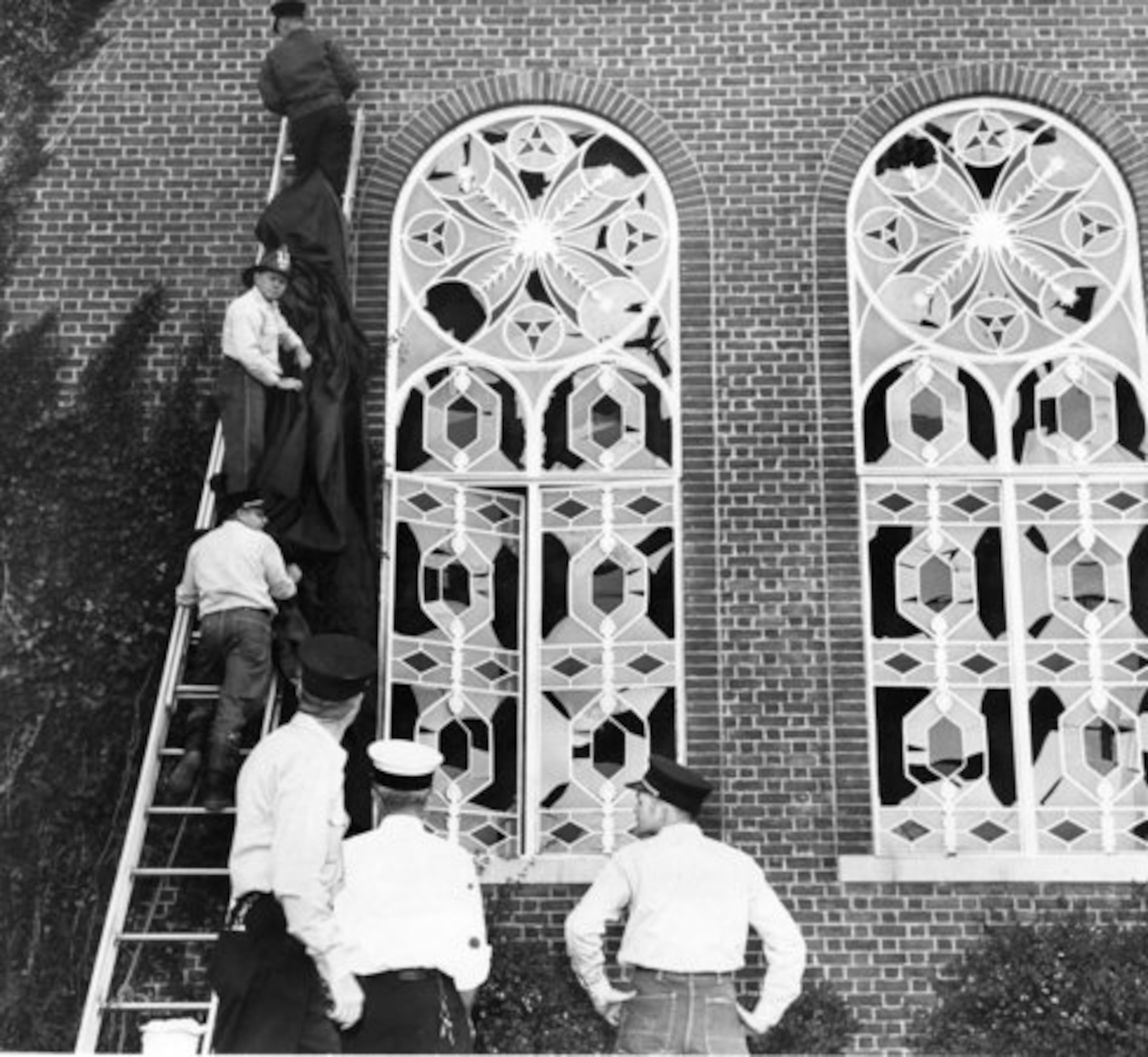 Twenty-six windows were shattered on the side of The Temple where the bomb was set off, and 12 more were damaged in the rest of the building. In this 1958 photo, firemen place canvas covers over damaged windows at The Temple.