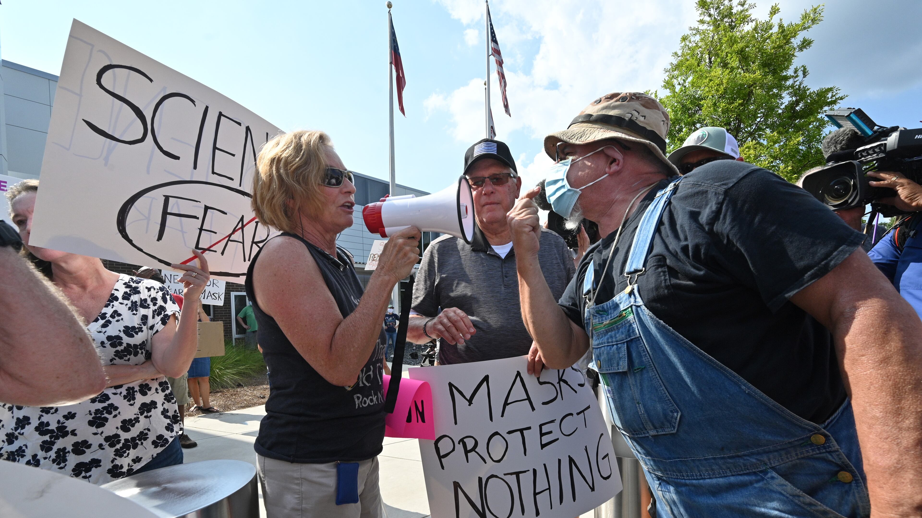 A demonstrator (right) demanding mask-mandate confronts a counter-protester at a rally in the parking lot of Cobb County School District's headquarters on Aug. 12, 2021. (Hyosub Shin / Hyosub.Shin@ajc.com)