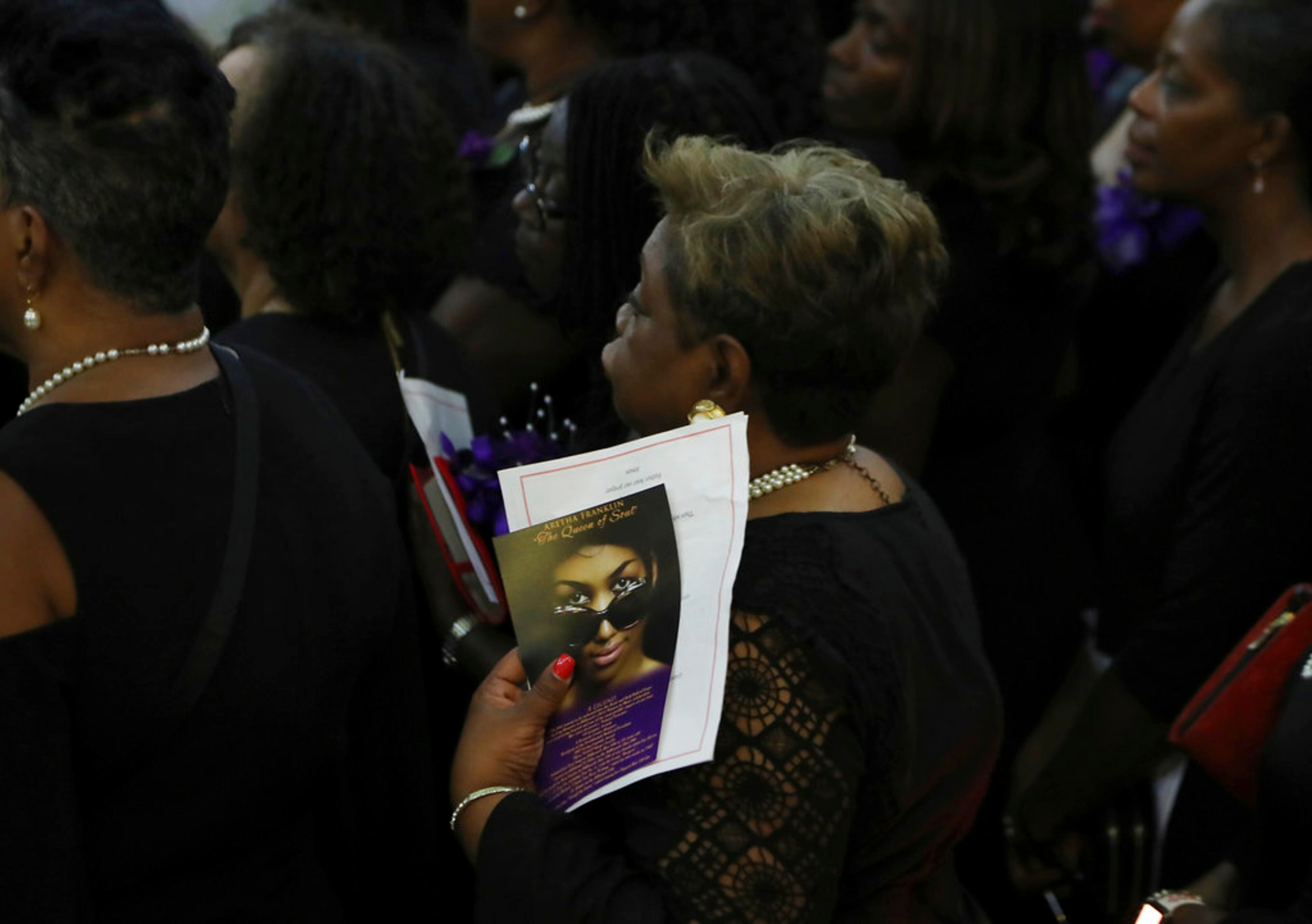 A member of Delta Sigma Theta holds an Aretha Franklin tribute as they pay tribute to the legendary singer at the Charles H. Wright Museum of African American History, Tuesday, Aug. 28, 2018, in Detroit. The sorority's traditional Omega Omega service lasted nearly an hour, saluting Franklin with song, scripture and words. Franklin, who was inducted into Delta Sigma Theta as an honorary member in 1992, was remembered as for her regal presence and love of her community. (AP Photo/Carlos Osorio)