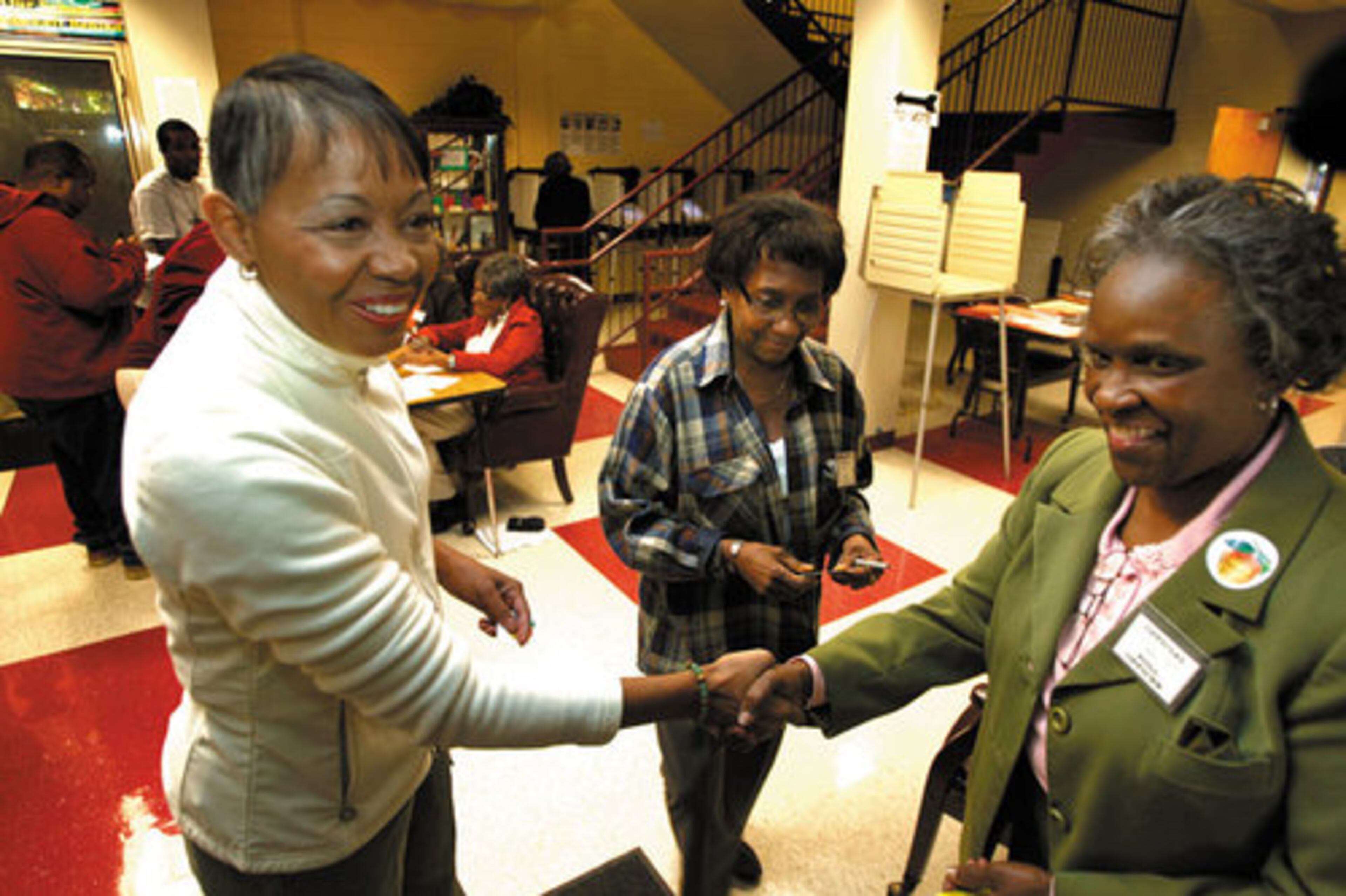 Atlanta mayoral candidate Lisa Borders (left) shakes hands with poll workers Juanita Peeks (center) and Amanda Hayes (right).