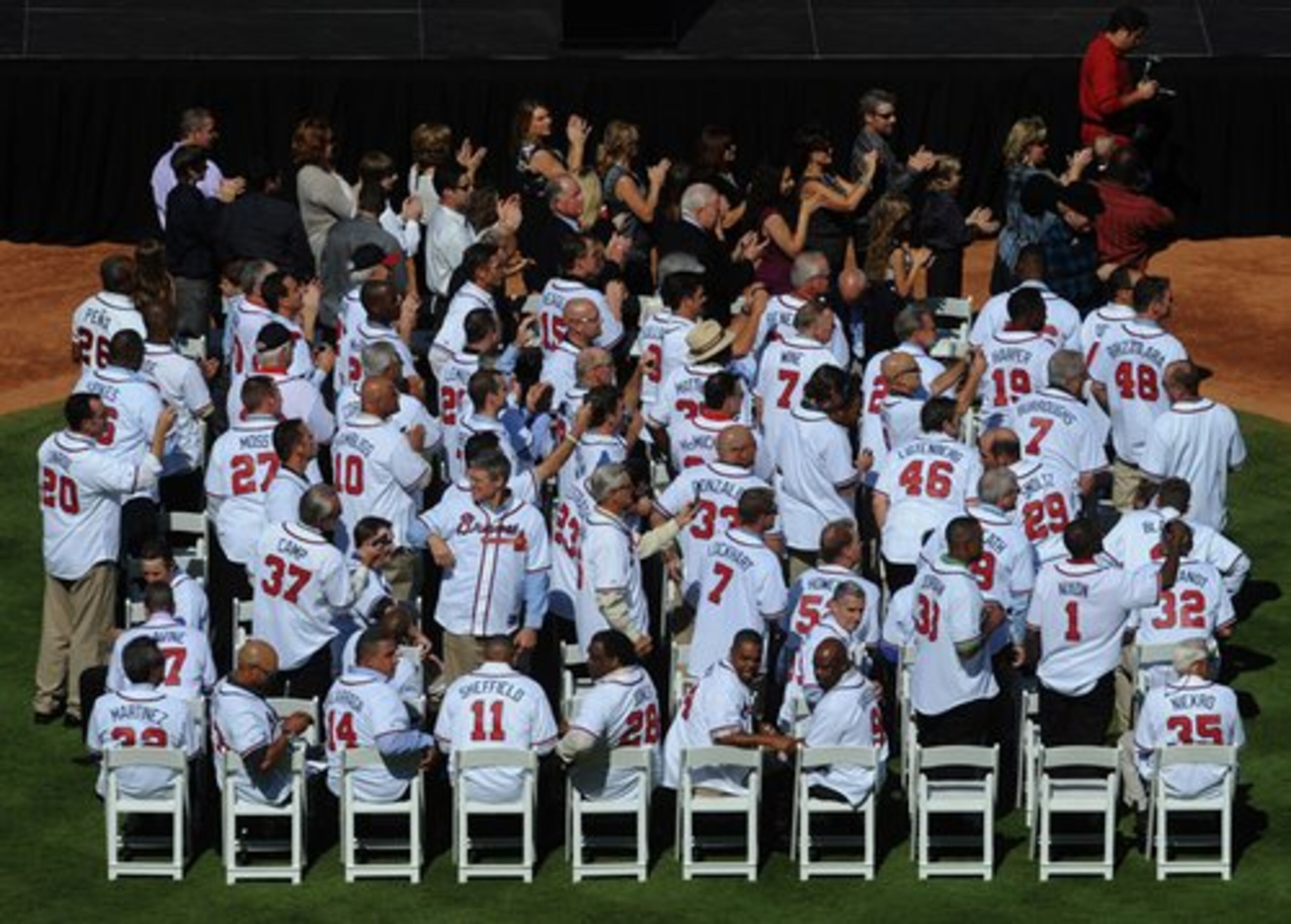 Former players stand to applaud Bobby Cox as he walks toward the state for pre-game ceremony. About 80 players turned out to the farewell ceremony for the Braves' retiring manager.