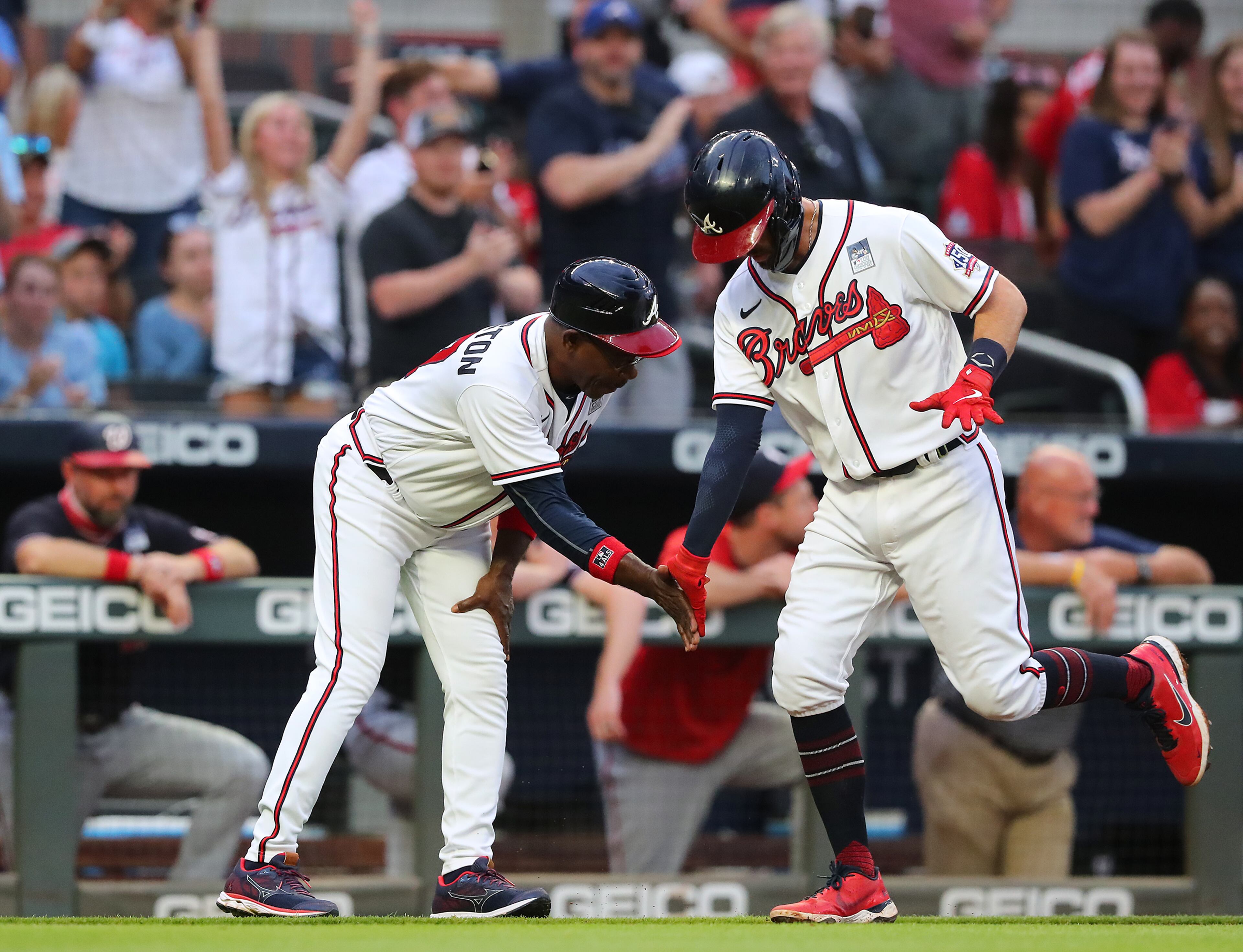 Braves batter Dansby Swanson gets five from third base coach Ron Washington as he heads home on his solo homer to tie the game 1-1 with the Washington Nationals during the second inning of a MLB baseball game on Wednesday, Jun 2, 2021, in Atlanta. “Curtis Compton / Curtis.Compton@ajc.com”