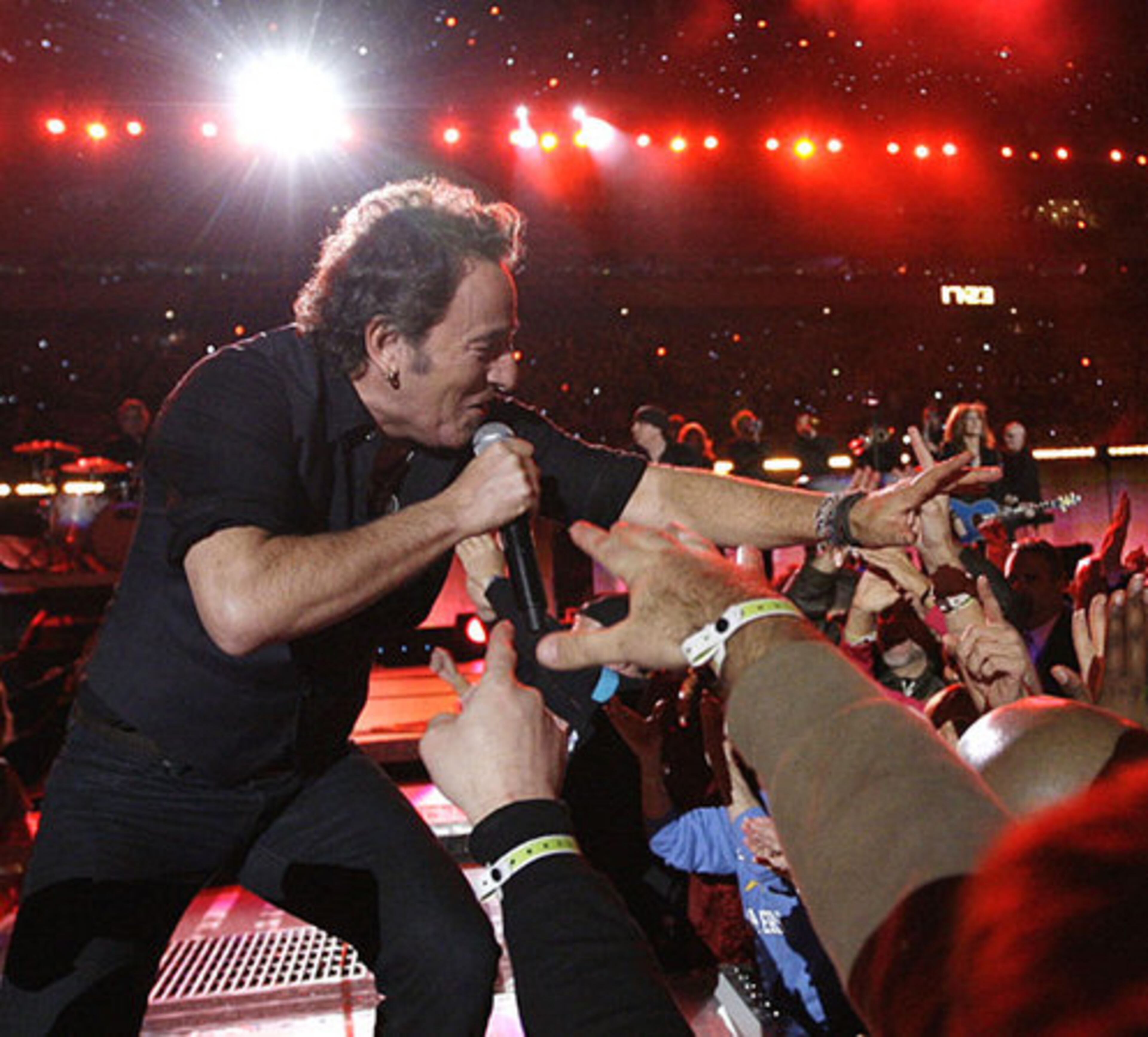 Known for his connection with audiences, Bruce Springsteen reaches out, literally, to the Super Bowl crowd.