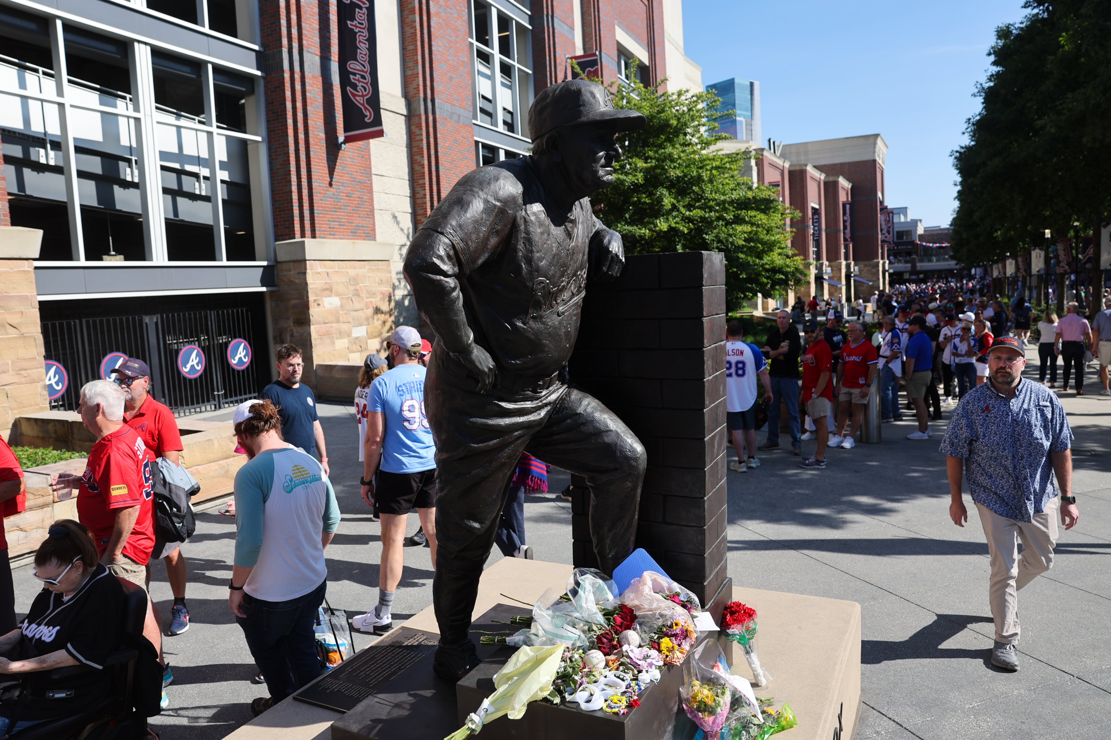 Fans left flowers and other items for the late legendary Braves manager Bobby Cox by his statue at Truist Park in Atlanta on May 12, 2026. Cox died at age 84 on Saturday May, 9. (Arvin Temkar/AJC)